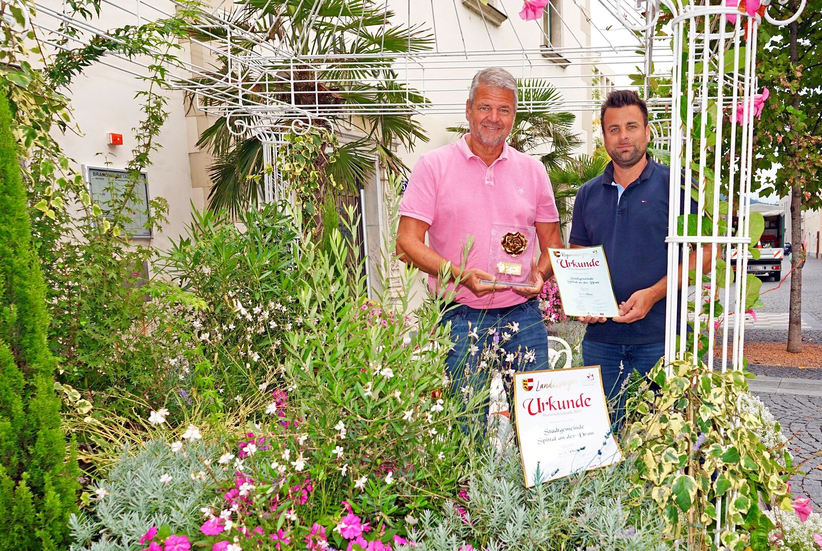 Gerhard Köfer und Daniel Santner mit den Urkunden inmitten von Pflanzen