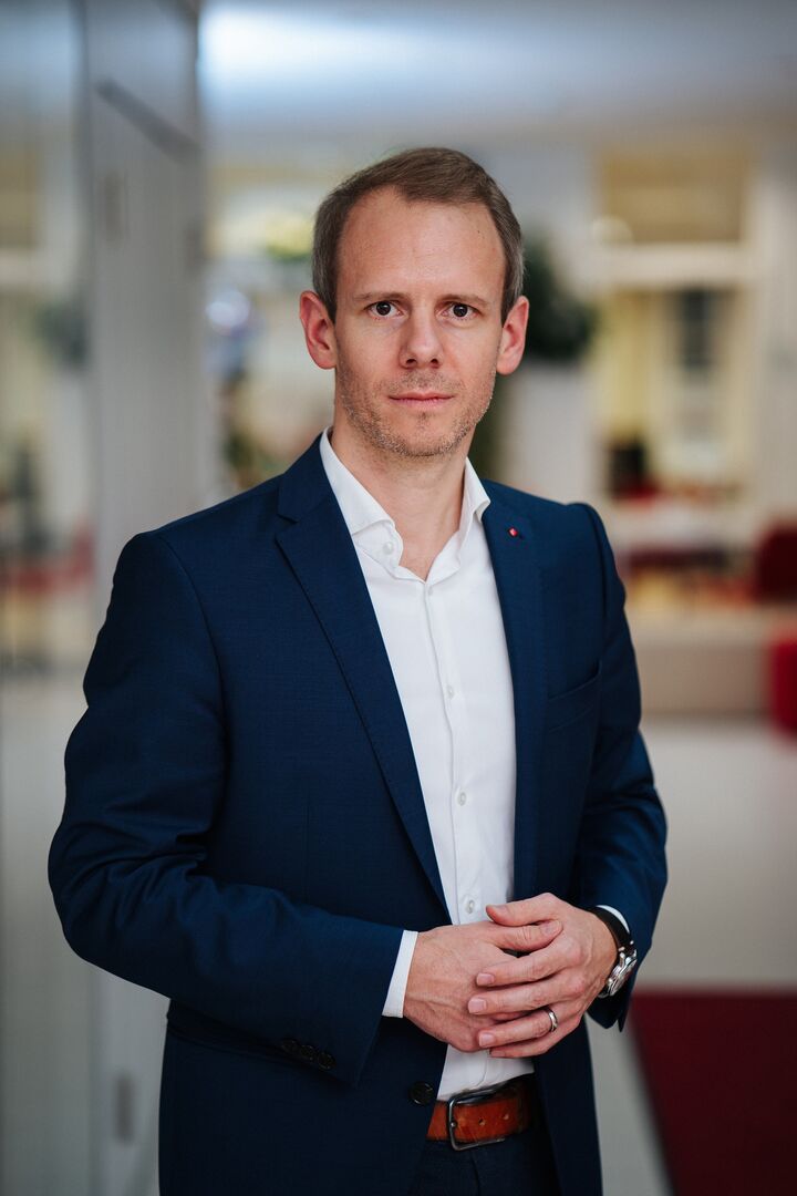 Porträtfoto von Andreas Sucher, der ein Sakko samt weißem Hemd trägt