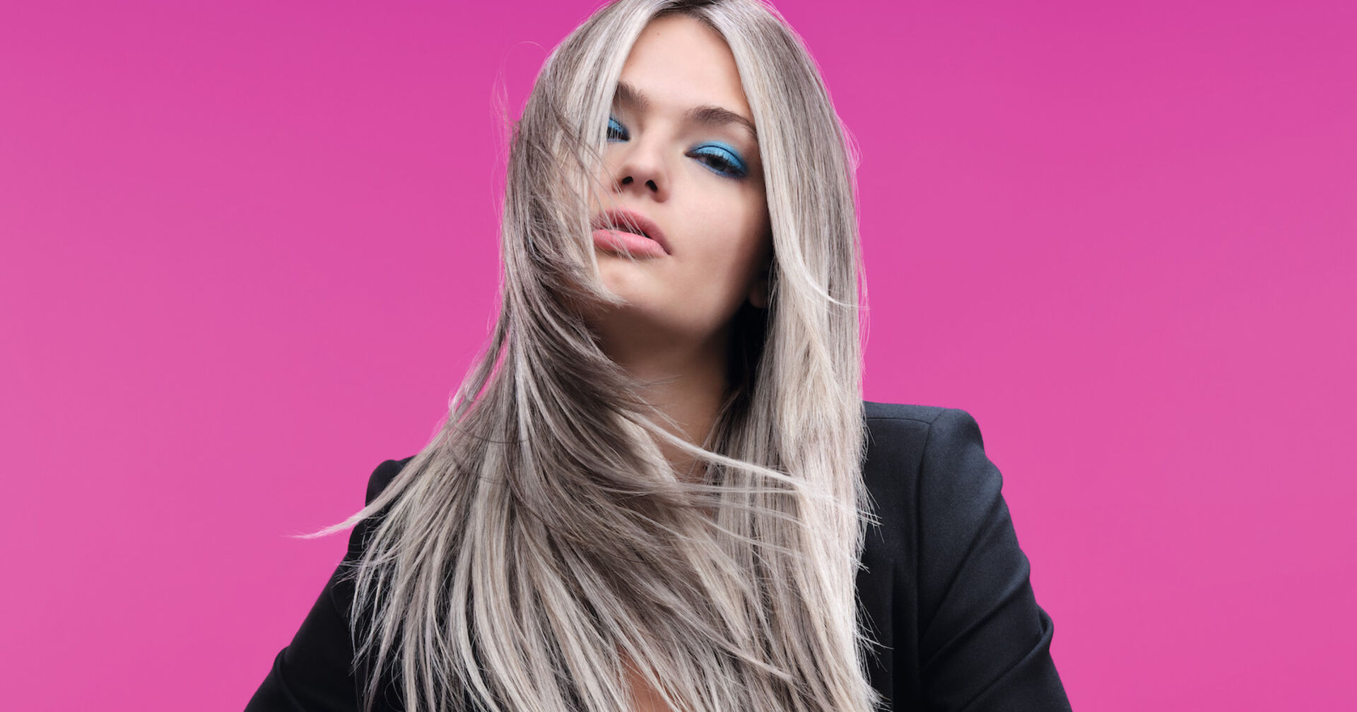 Blondes Model vor einer pinken Wand bei einem Fotoshootings