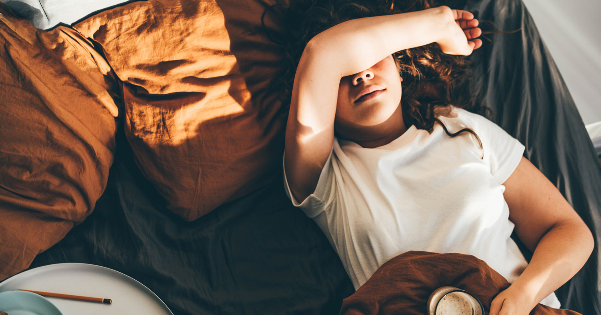 Frau liegt im Bett | Credit: iStock.com/Maria Korneeva