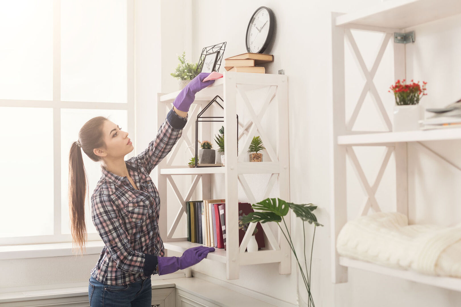Frau beim Staubwischen | Credit: iStock.com/Prostock-Studio