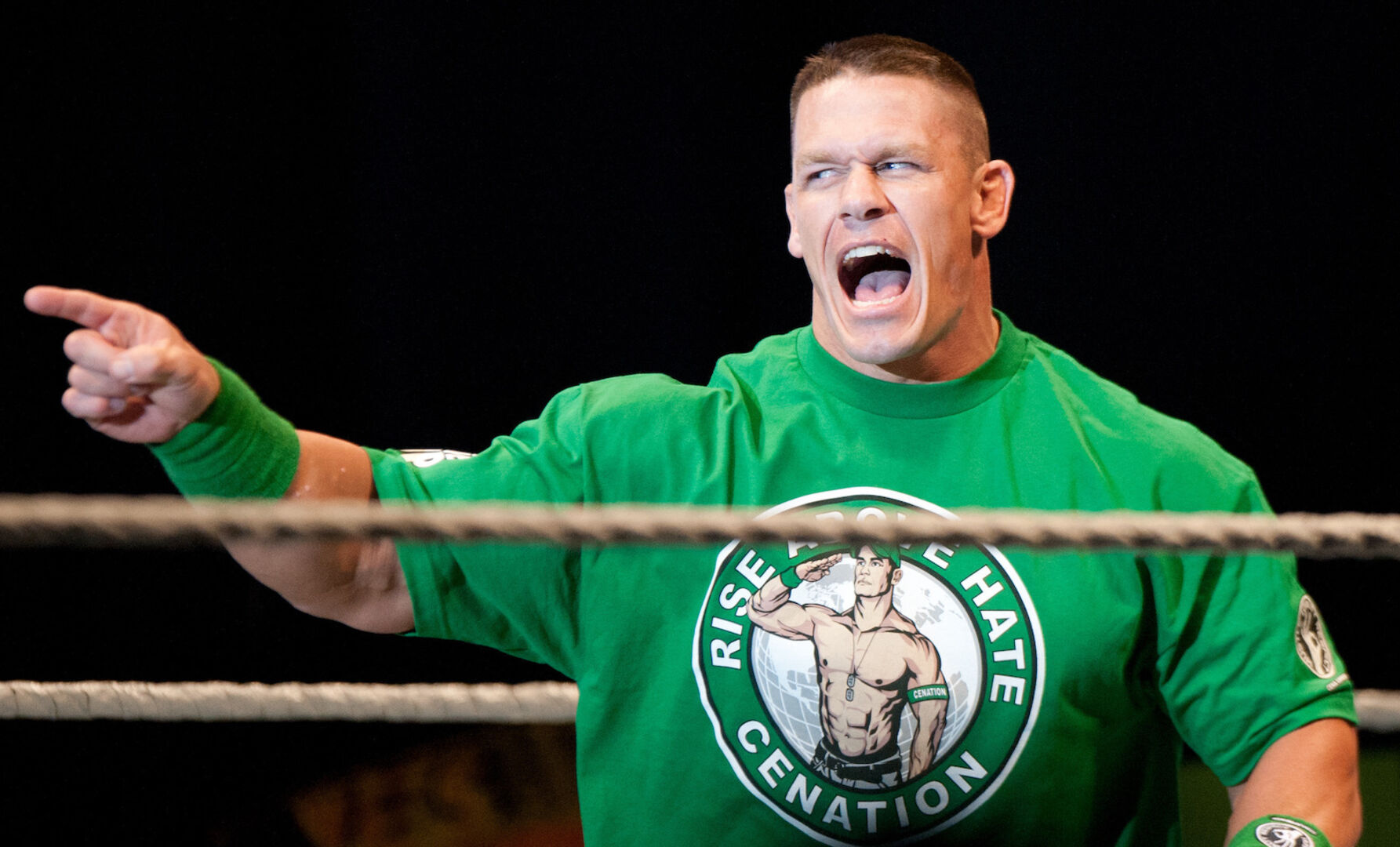 Ein muskulöser Mann in einem Boxring mit einem grünen T-Shirt.