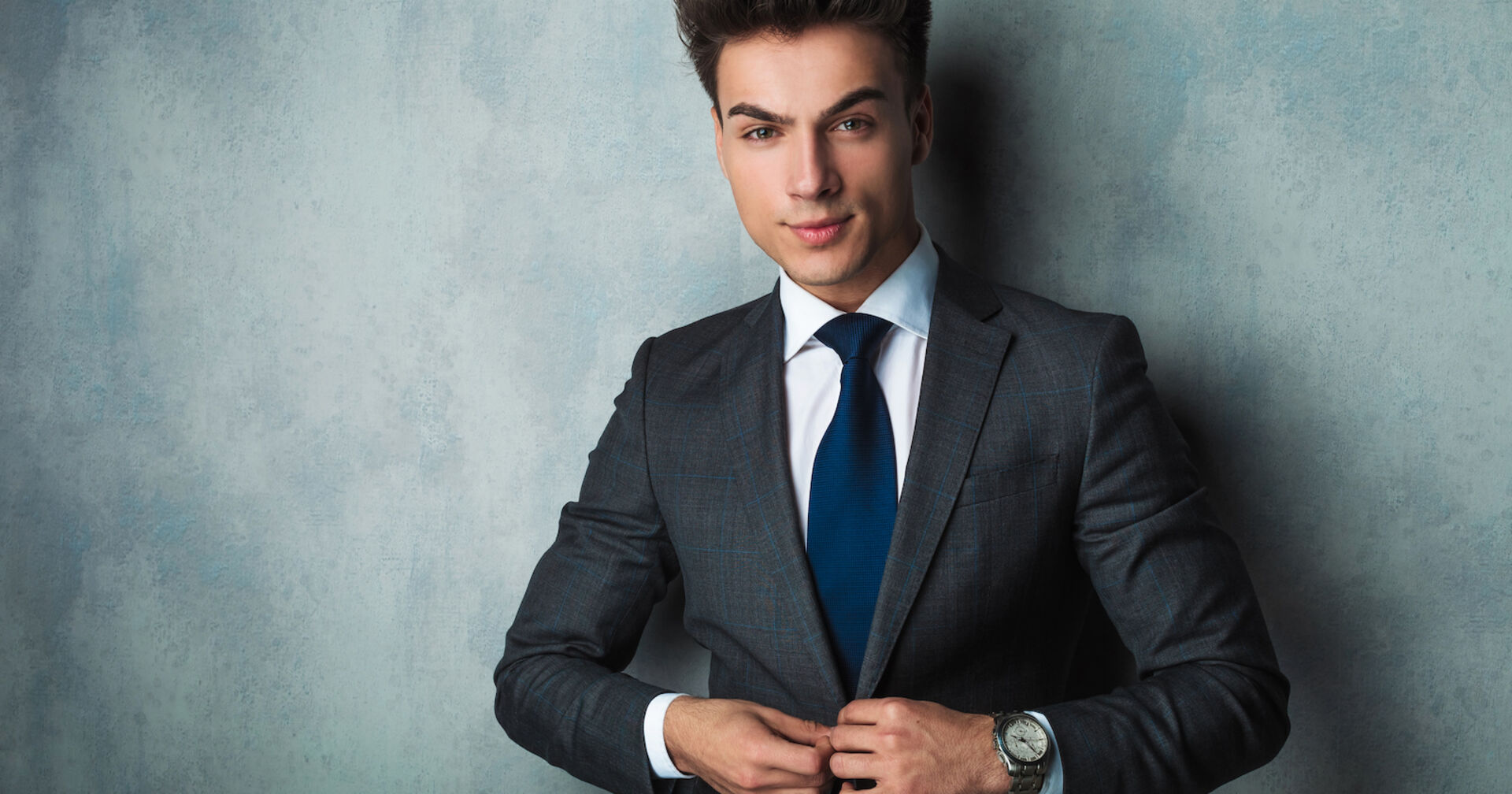 junger Mann knöpft Anzugjacke zu | Credit: istock.com/feedough