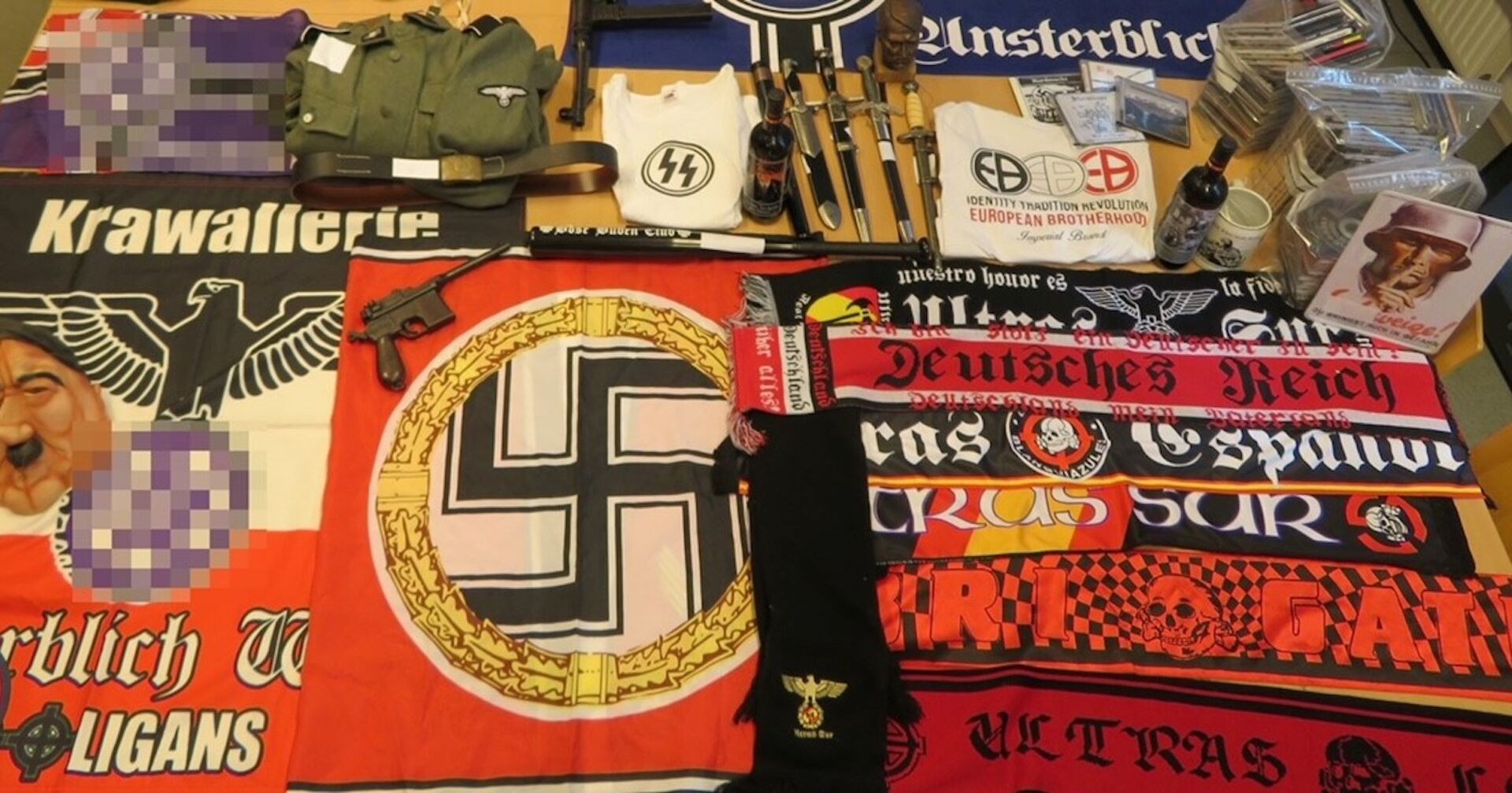 Die gefundenen NS-Devotionalien, darunter Flaggen, Pistolen und Shirts.
