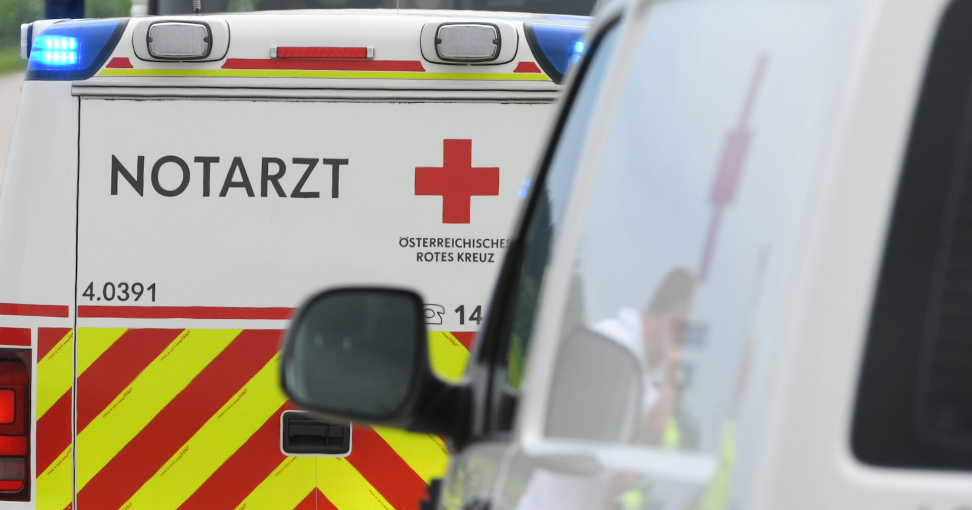 Ein Notarztwagen von hinten, das Blaulicht ist an.