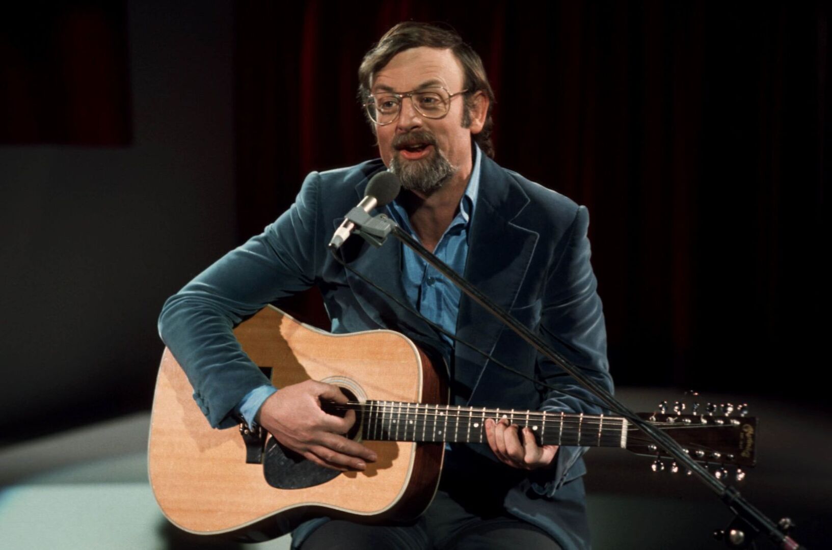 Der junge Roger Whittaker mit Gitarre auf der Bühne.
