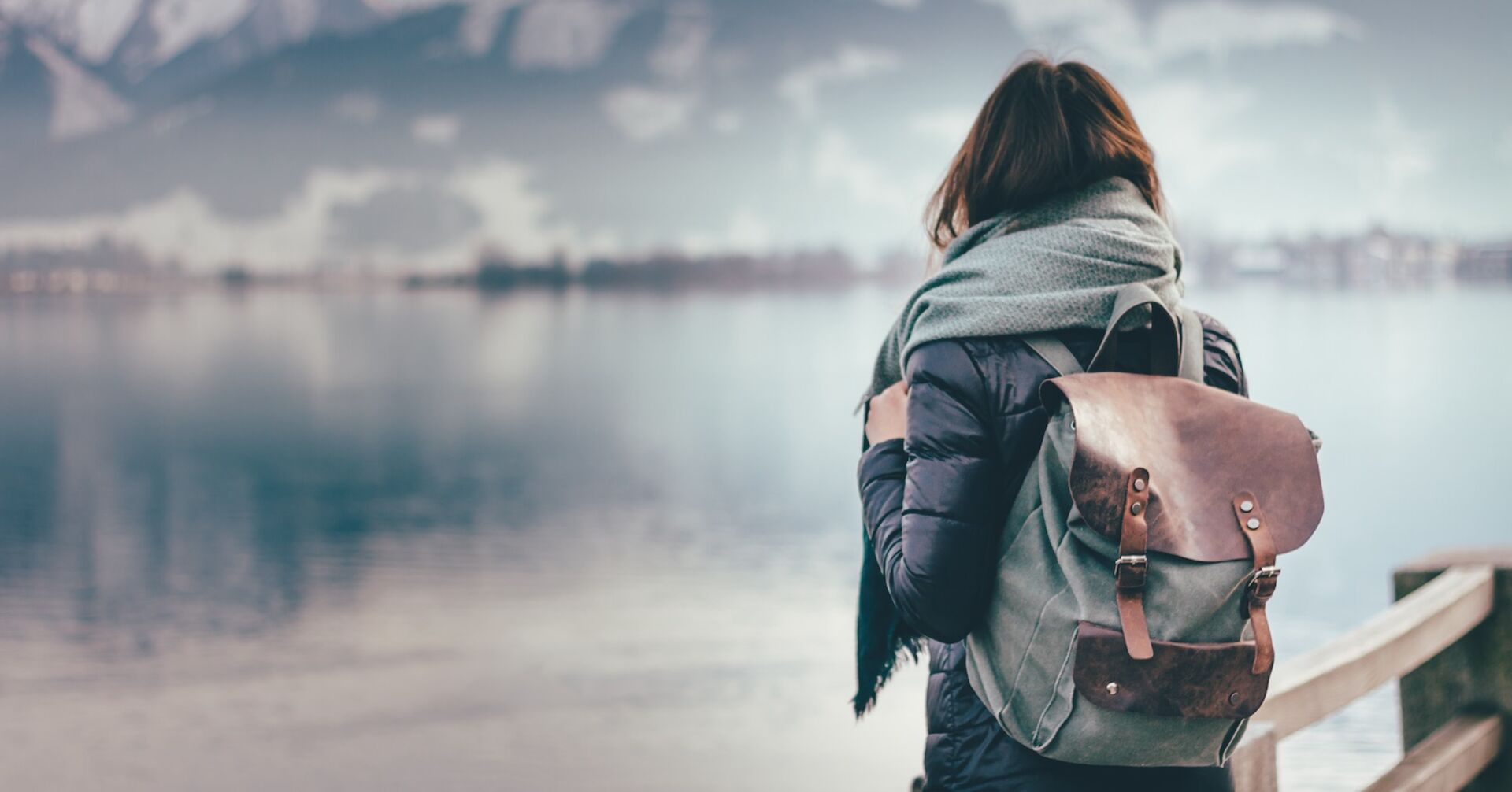 Frau mit Rucksack schaut auf einen See