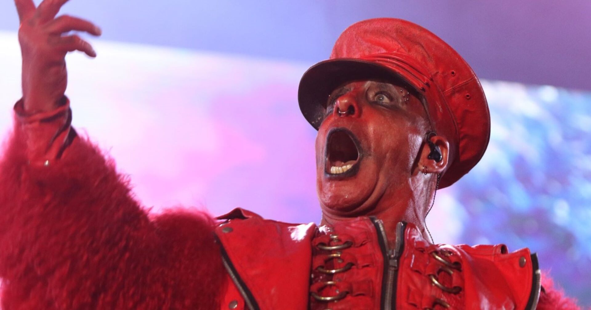 Lindemann in einem roten Bühnenoutfit, ganz rot geschminkt bei einem Auftritt