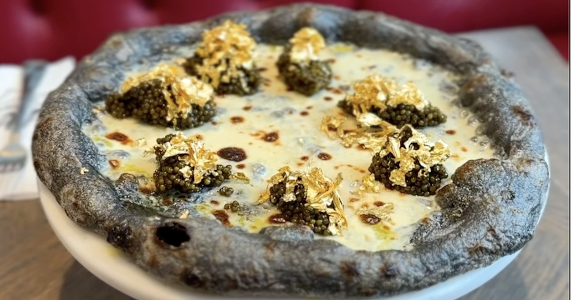 Eine Pizza mit violetten Rand, Blattgold und Kaviar.