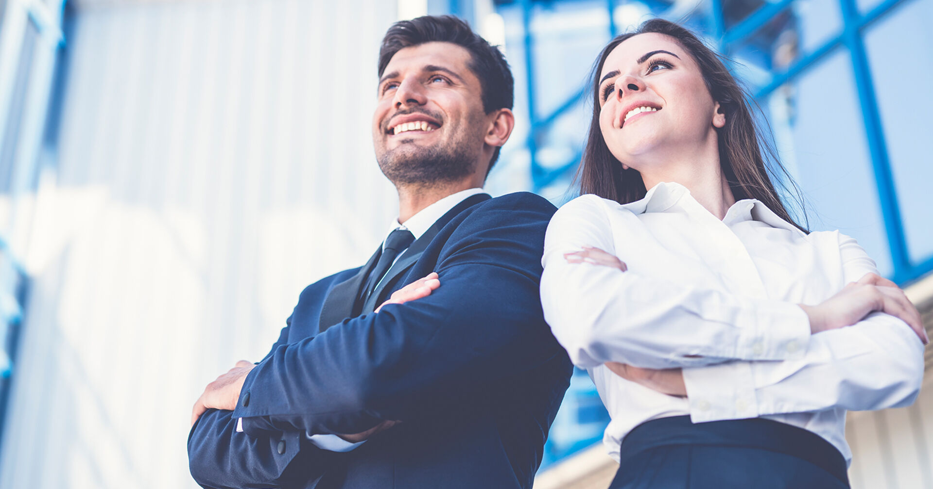 Junge erfolgreiche Frau und junger erfolgreicher Mann in blauer Businesskleidung | Credit: iStock.com/Viacheslav Peretiatko