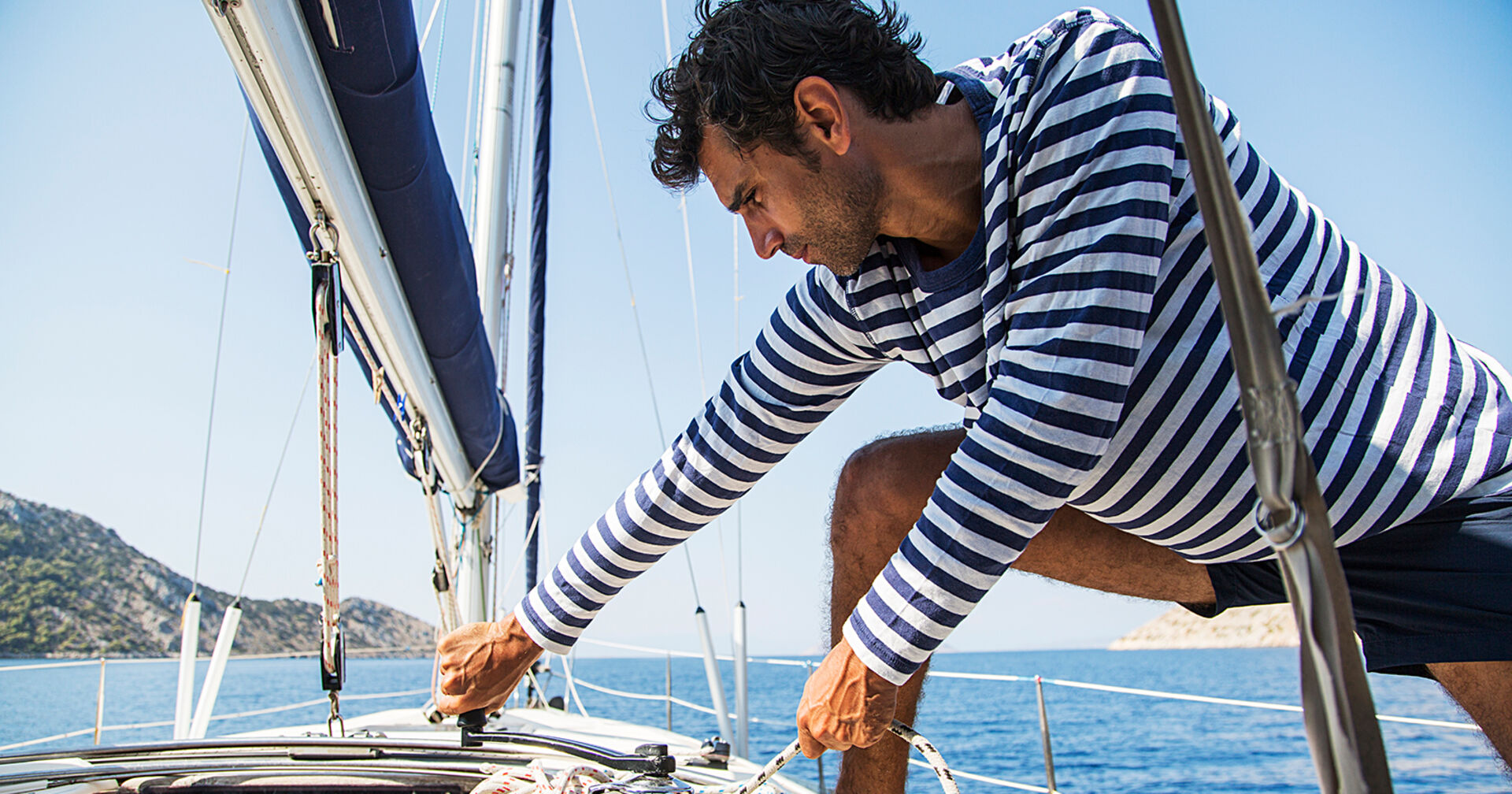 Mann setzt die Segel | Credit: iStock.com/boggy22