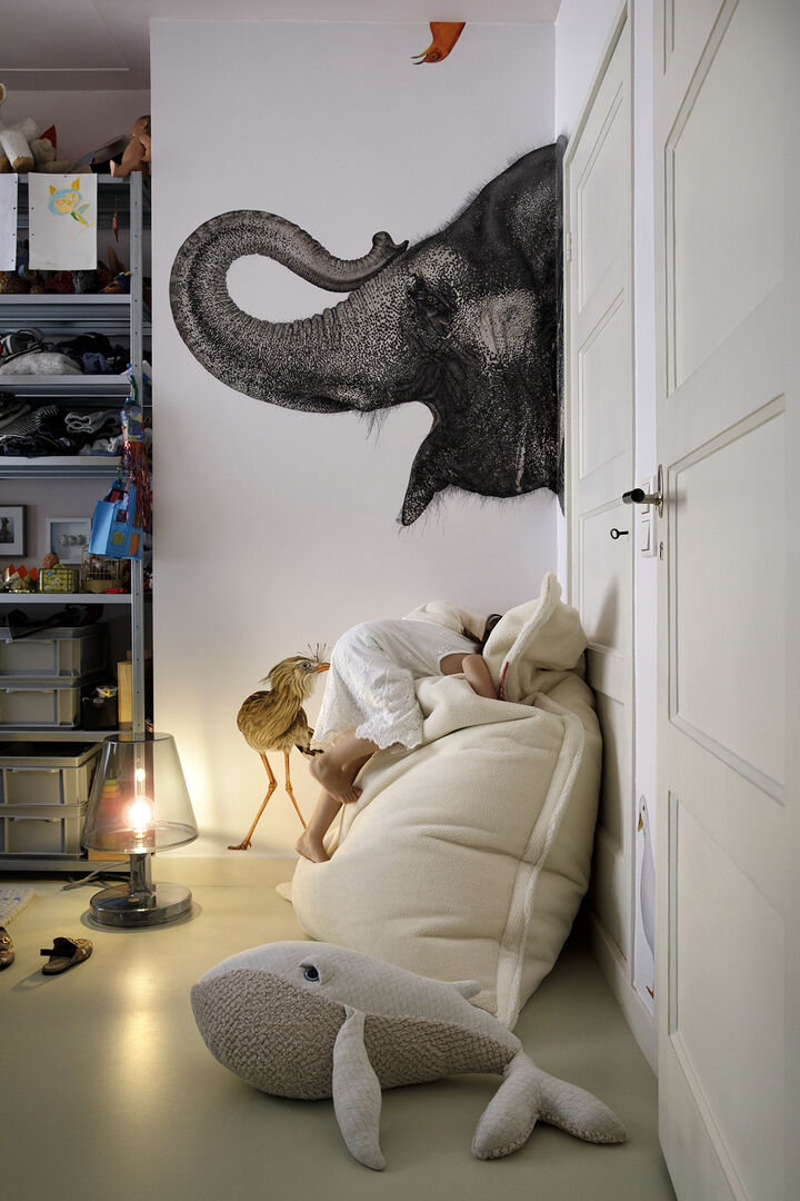 Kind vergräbt sich in beigen Sitzsack im Kinderzimmer