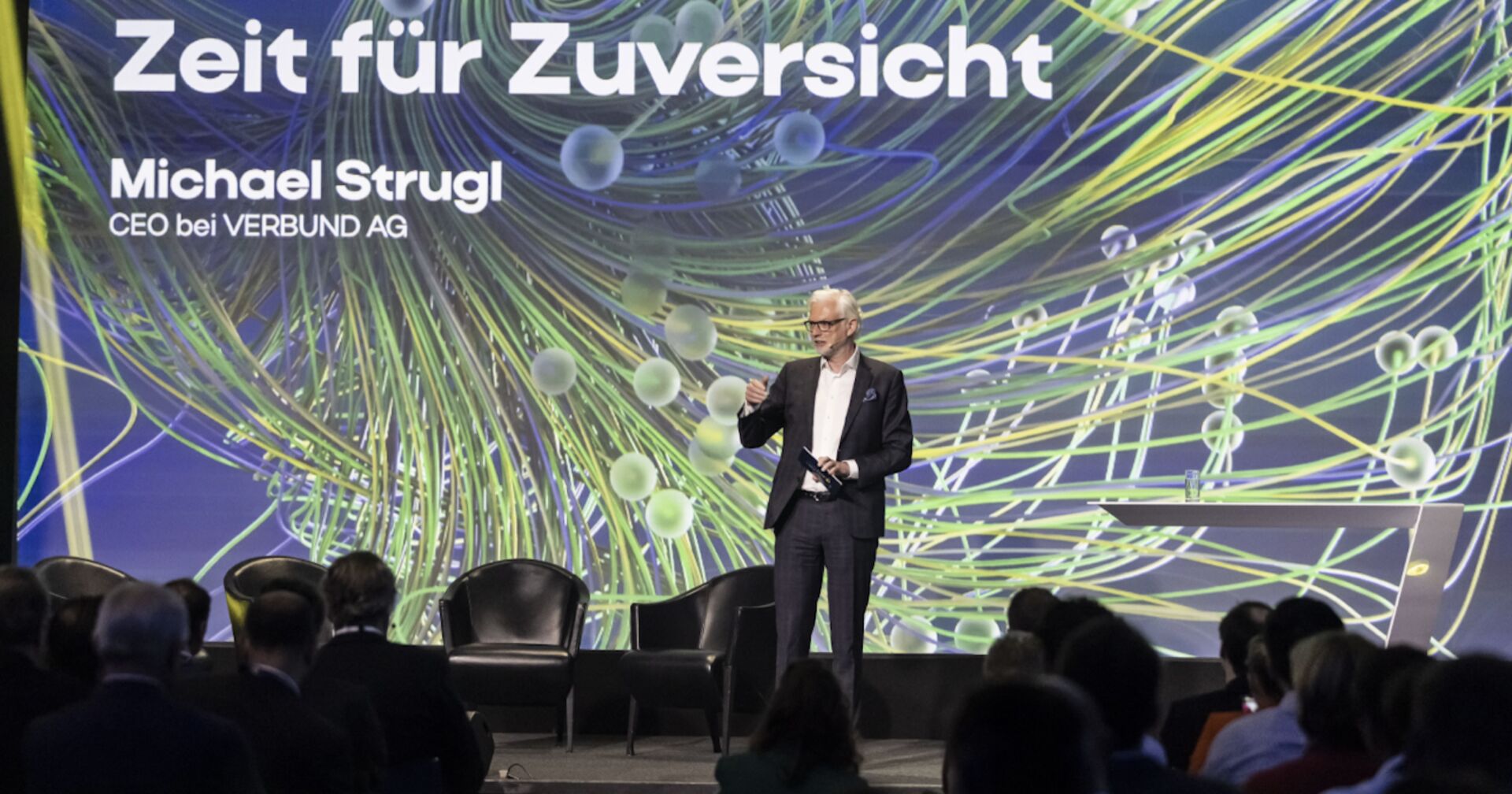 Ein Mann in der Mitte einer Bühne mit Schriftzug hinter ihm: Zeit für Zuversicht