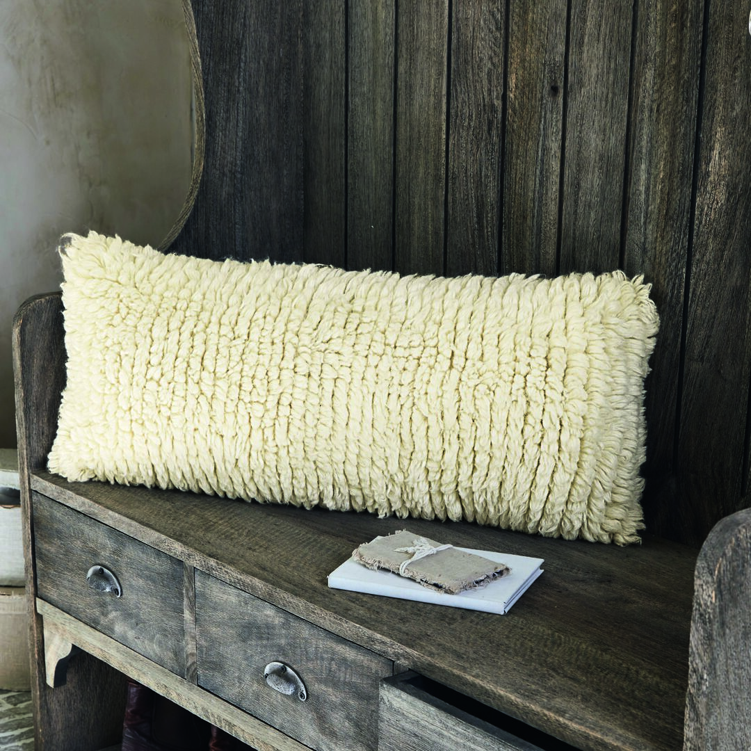 Fell-Kissen auf Holzbank