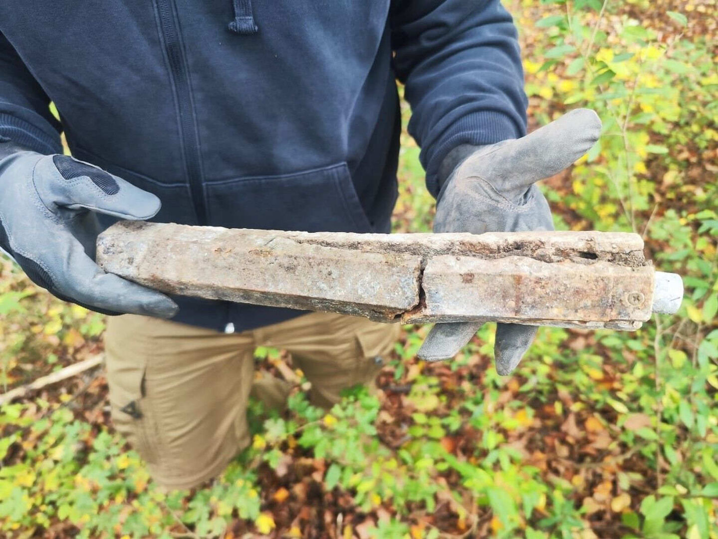 Ein Mann hält die gefundene Bombe in den Händen.