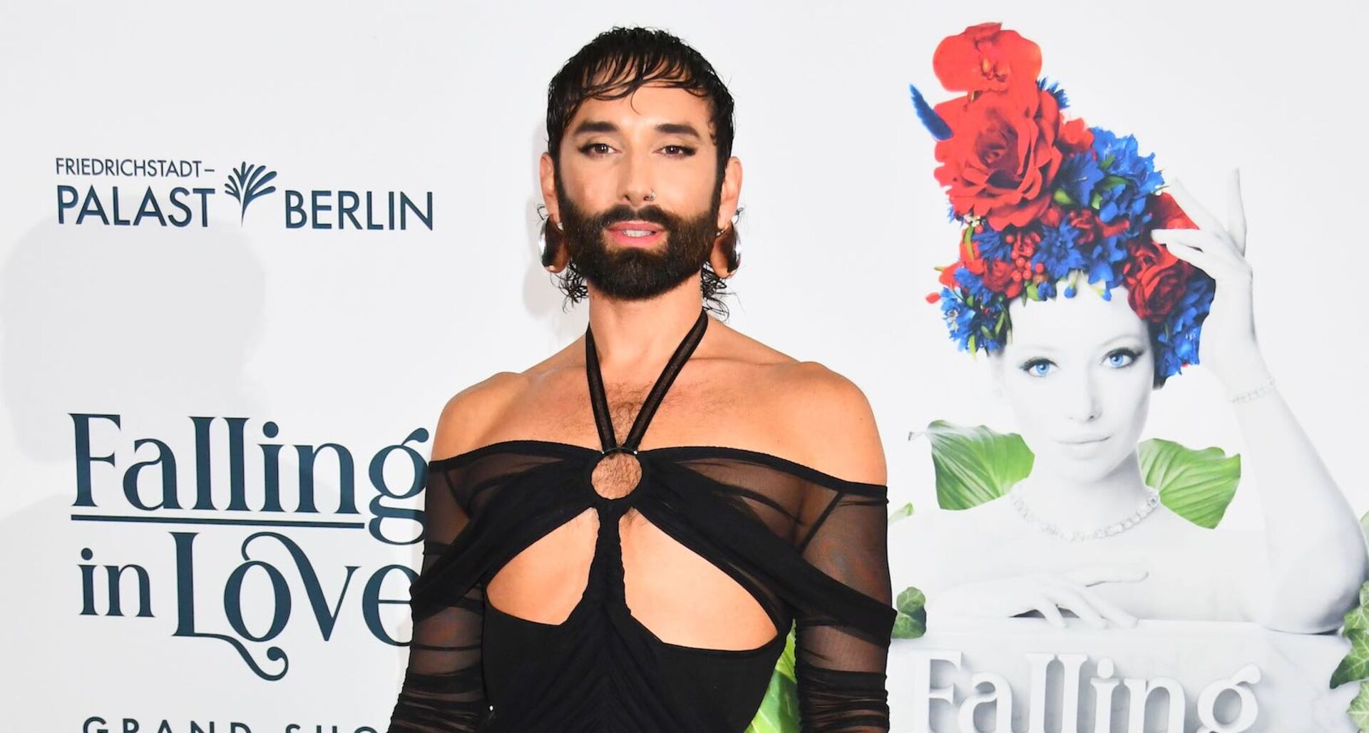 Conchita Wurst am Red Carpet mit einem freizügigen schwarzen Kleid und kurzen schwarzen Haaren.