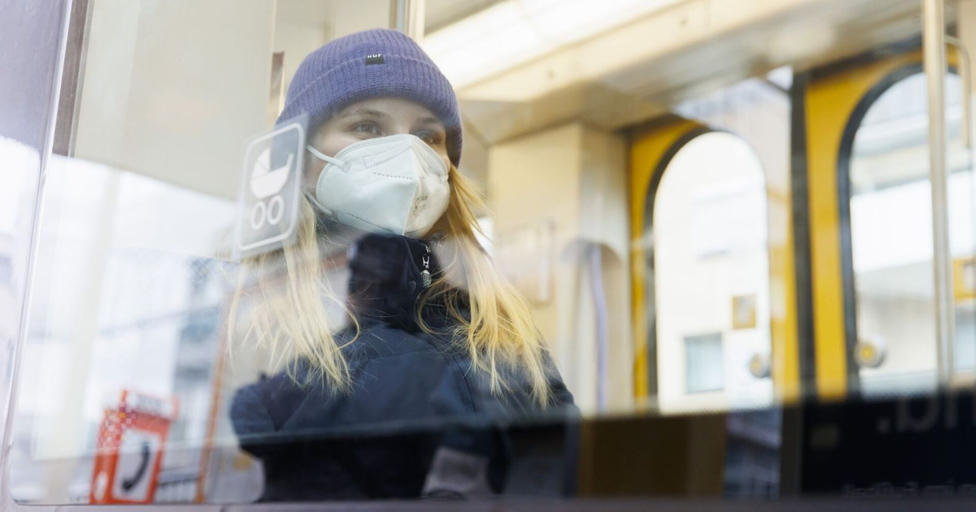 Frau mit Schutzmaske in einer Straßenbahn.