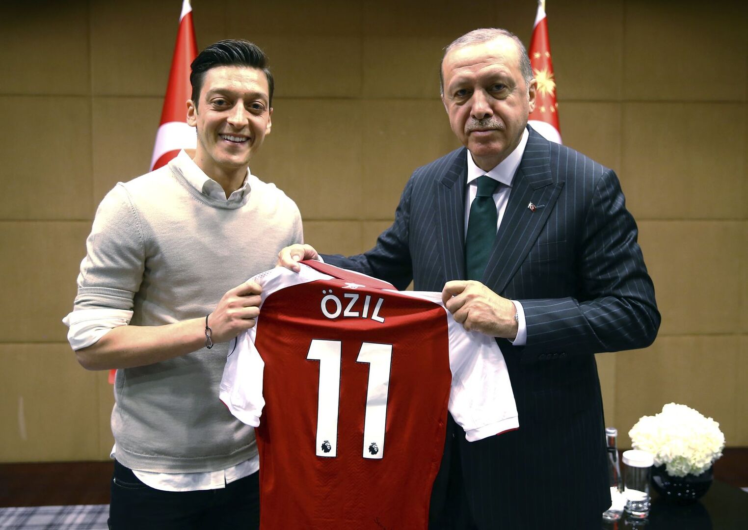 Mesut Özil mit und  Recep Tayyip Erdoğan halten ein Trikot in den Händen.