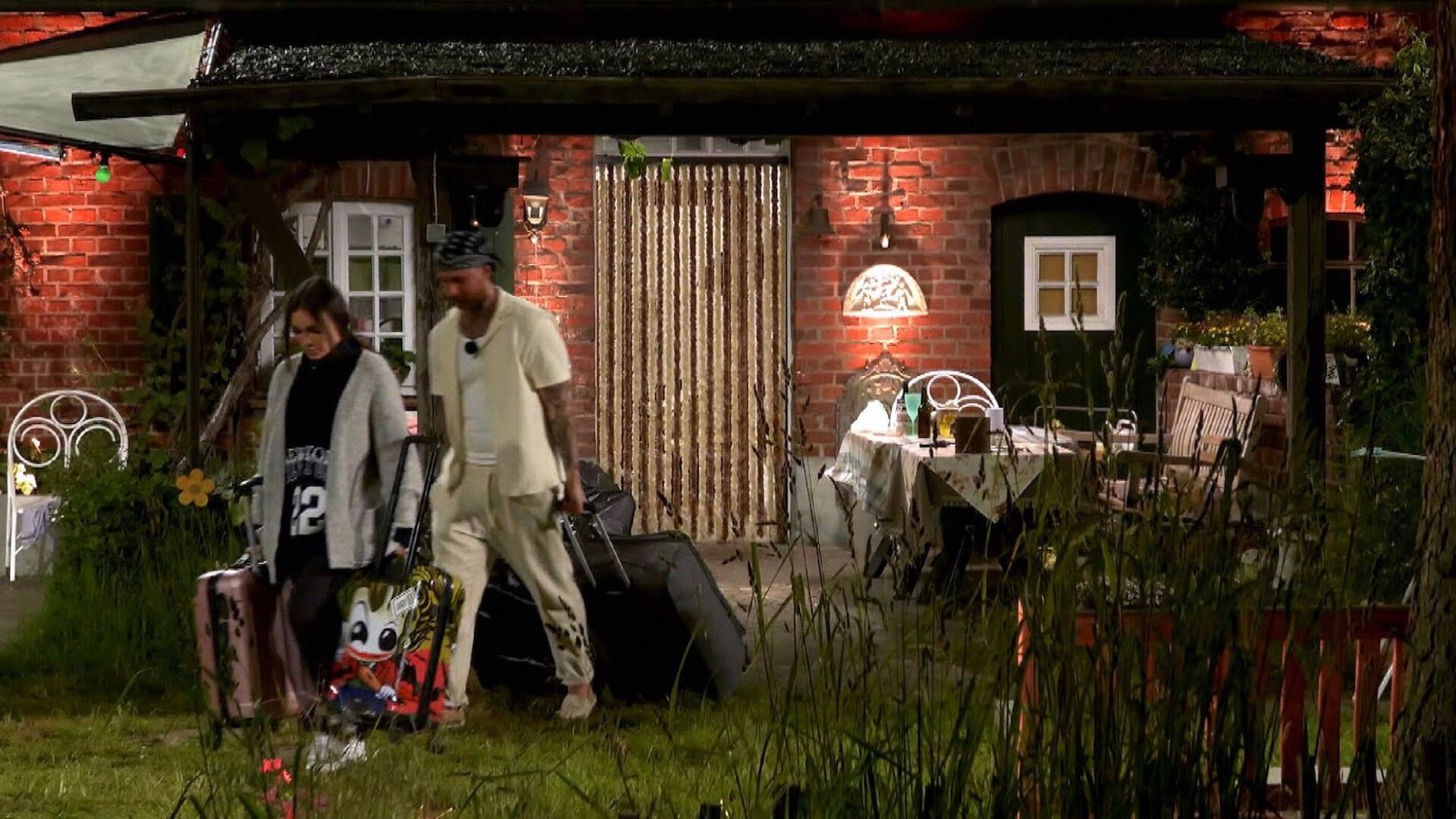 Gigi und Dana verlassen mit ihren Koffern das Set.