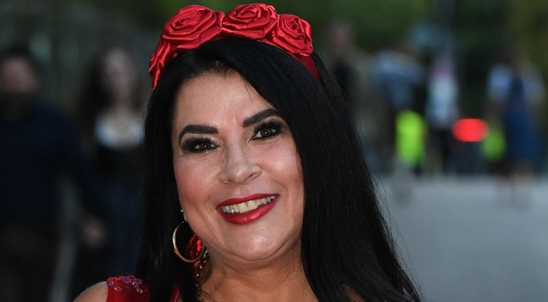 Iris Klein mit glatten schwarzen Haare und einem Rosenhaarreif.