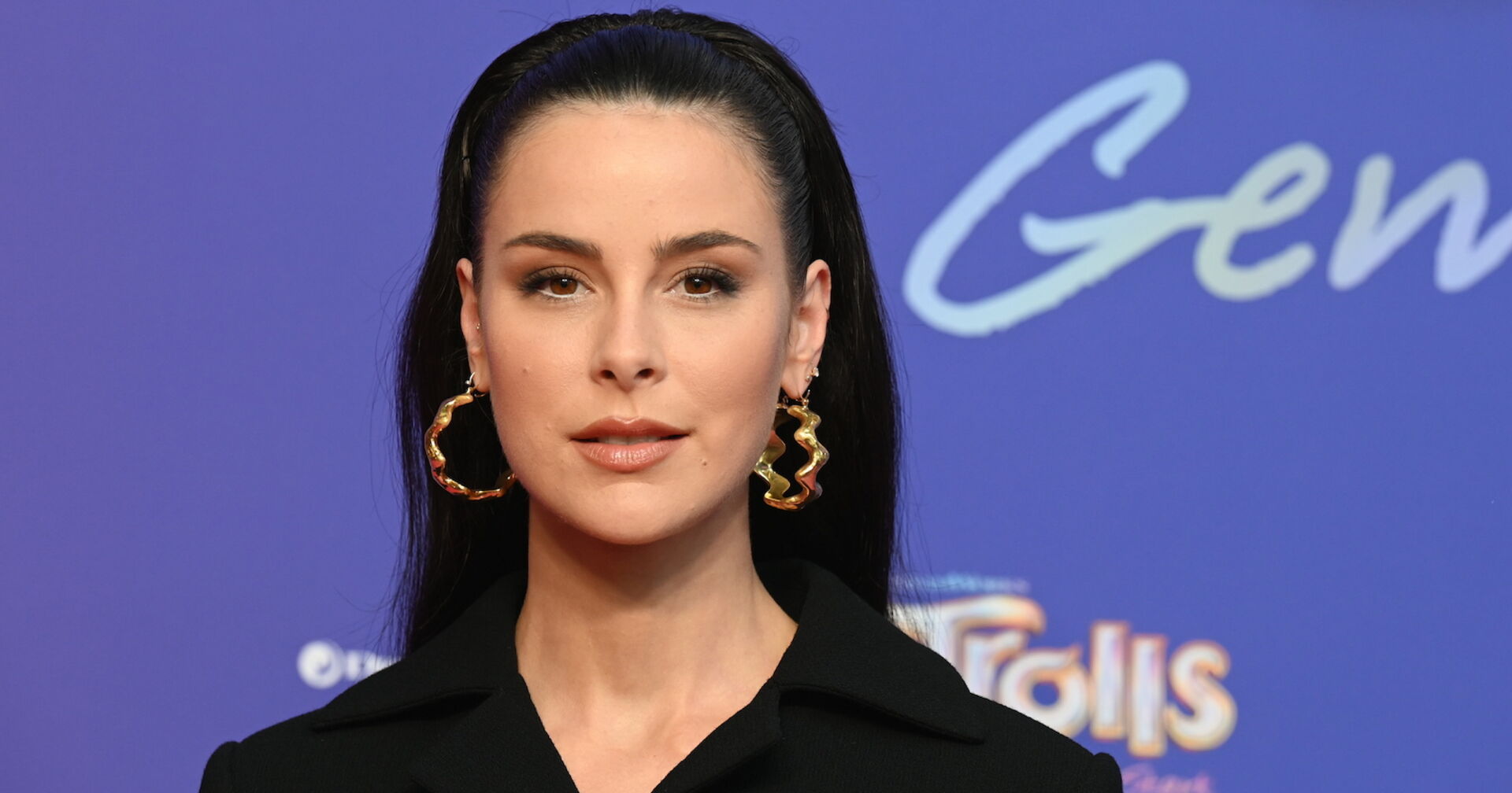 Lena Meyer Landrut mit offenen Haaren, einem Haarreifen, großen Ohrringen und einem schwarzen Sakko.