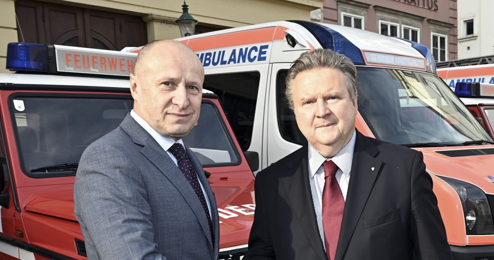 Bürgermeister Ludwig und der ukrainische Botschafter vor Einsatzfahrzeugen der Feuerwehr und Rettung.