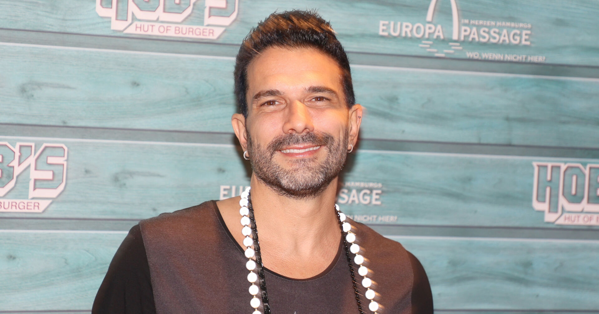 Marc Terenzi vor einer Fotoleinwand mit einer großen Kette.