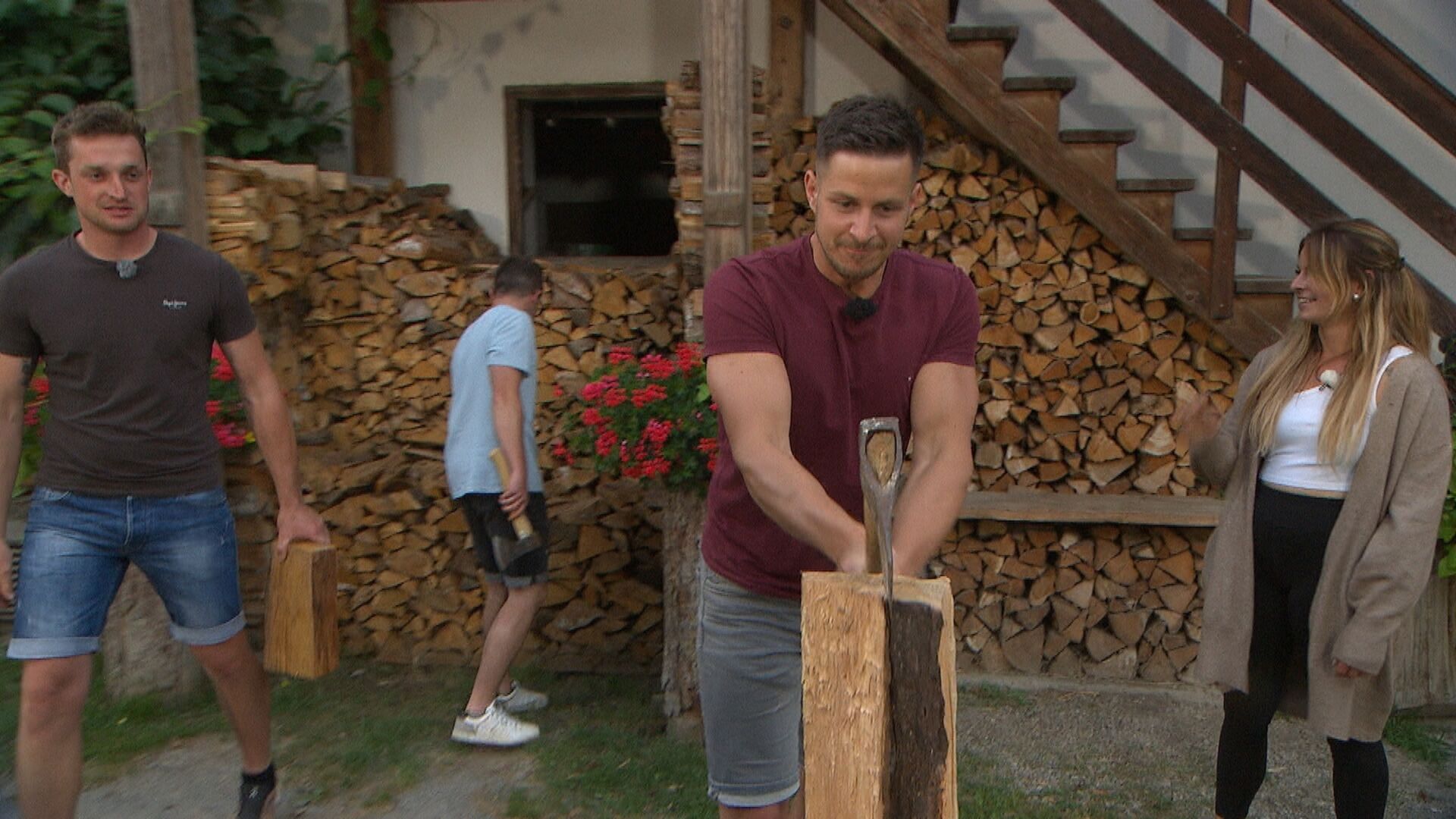 Kandidat Stefan hackt Holz. Dabei trägt er ein weinrotes T-Shirt.