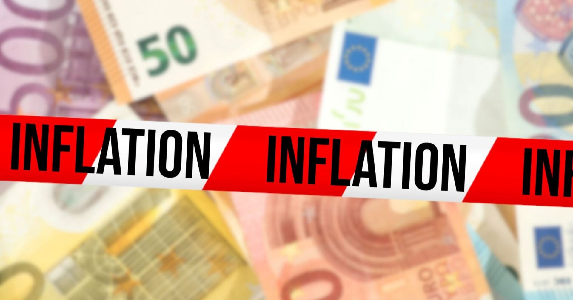 Mehrere Geldscheine übereinander, darüber ein Sperrband mit der Aufschritt &quot;Inflation&quot;