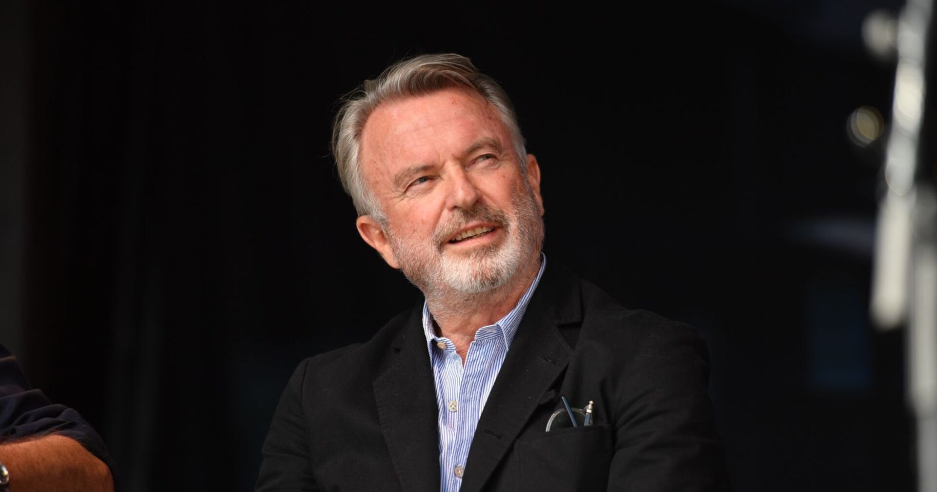 Sam Neill wirkt nachdenklich.