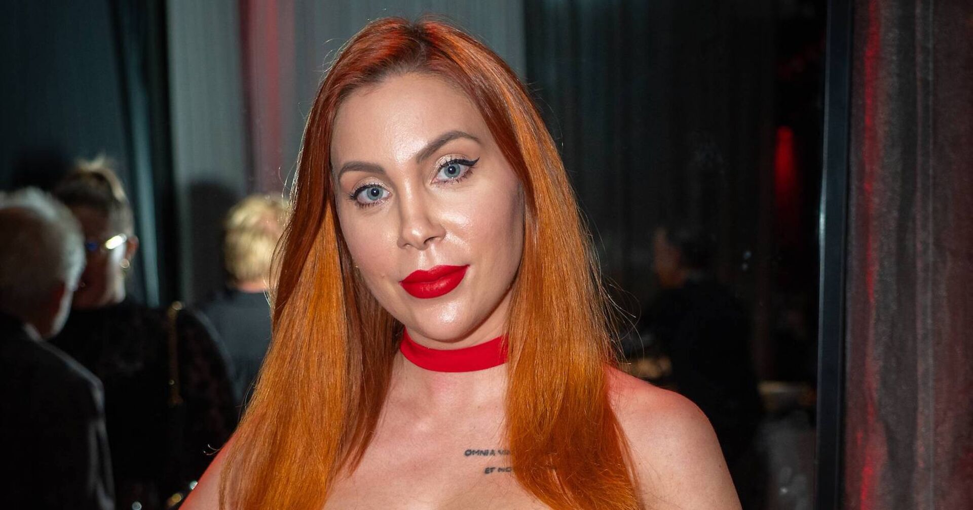 Tara Tabitha mit einem roten Lippenstift und langen kupfer Haaren.