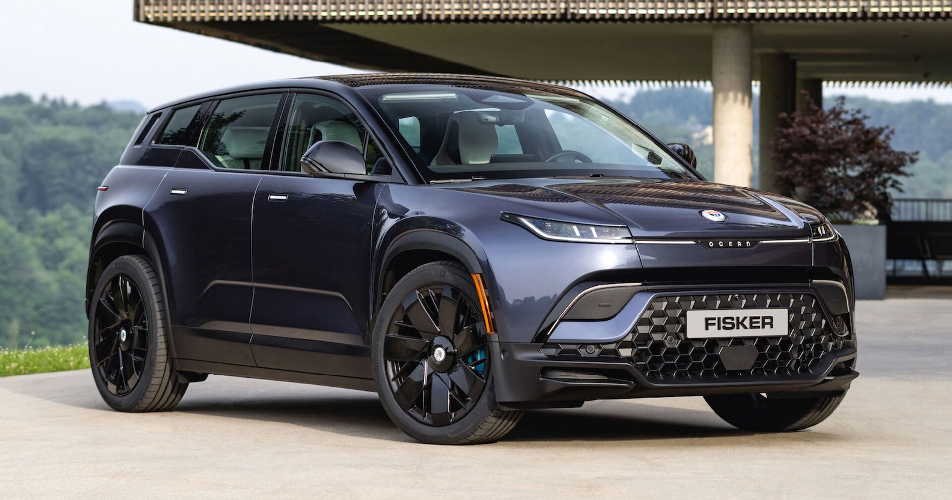 Das SUV Fisker Ocean am Parkplatz mit Naturlandschaft im Hintergrund
