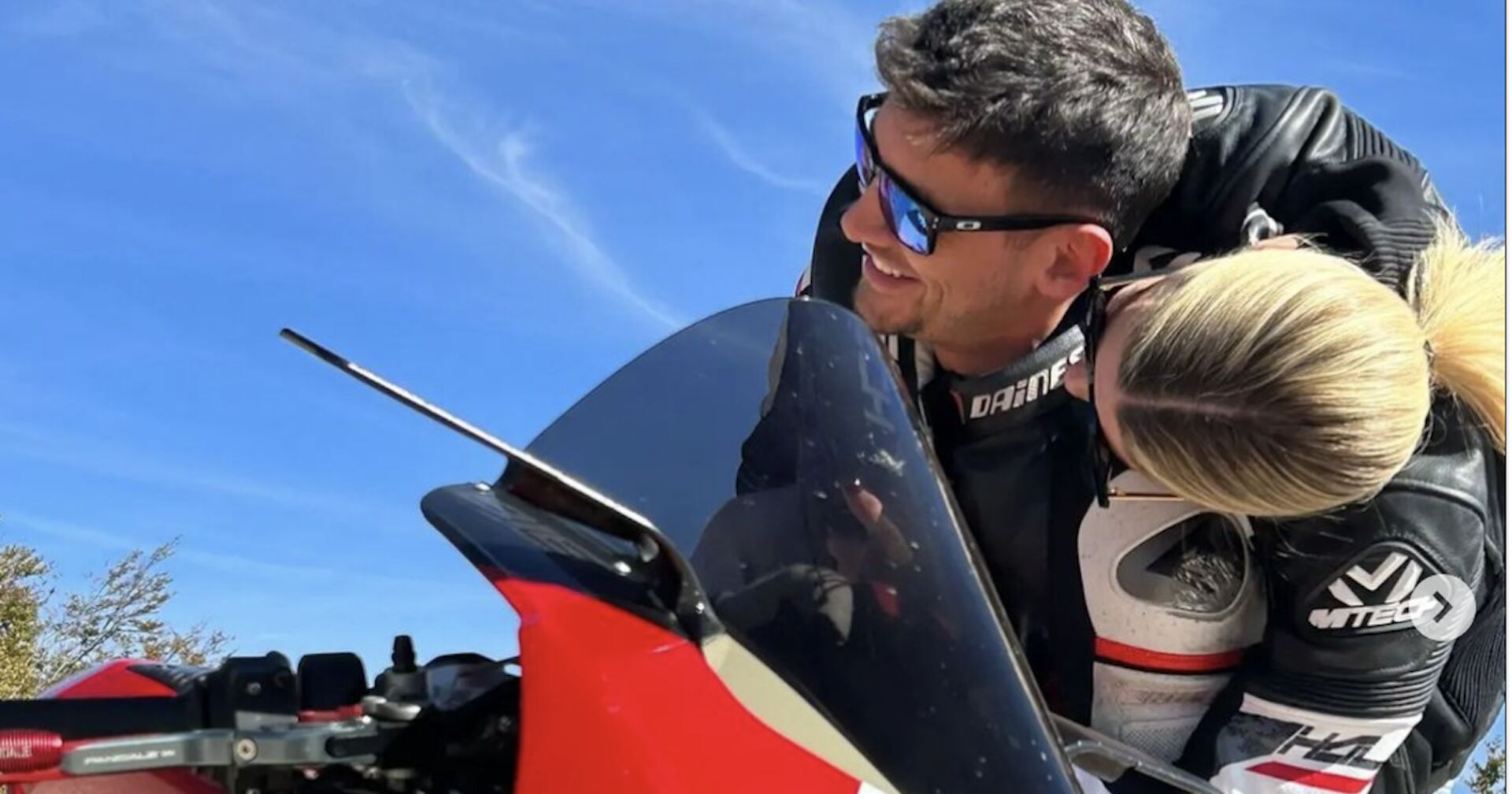 Beide auf dem Motorrad, Gesichter leicht abgewandt