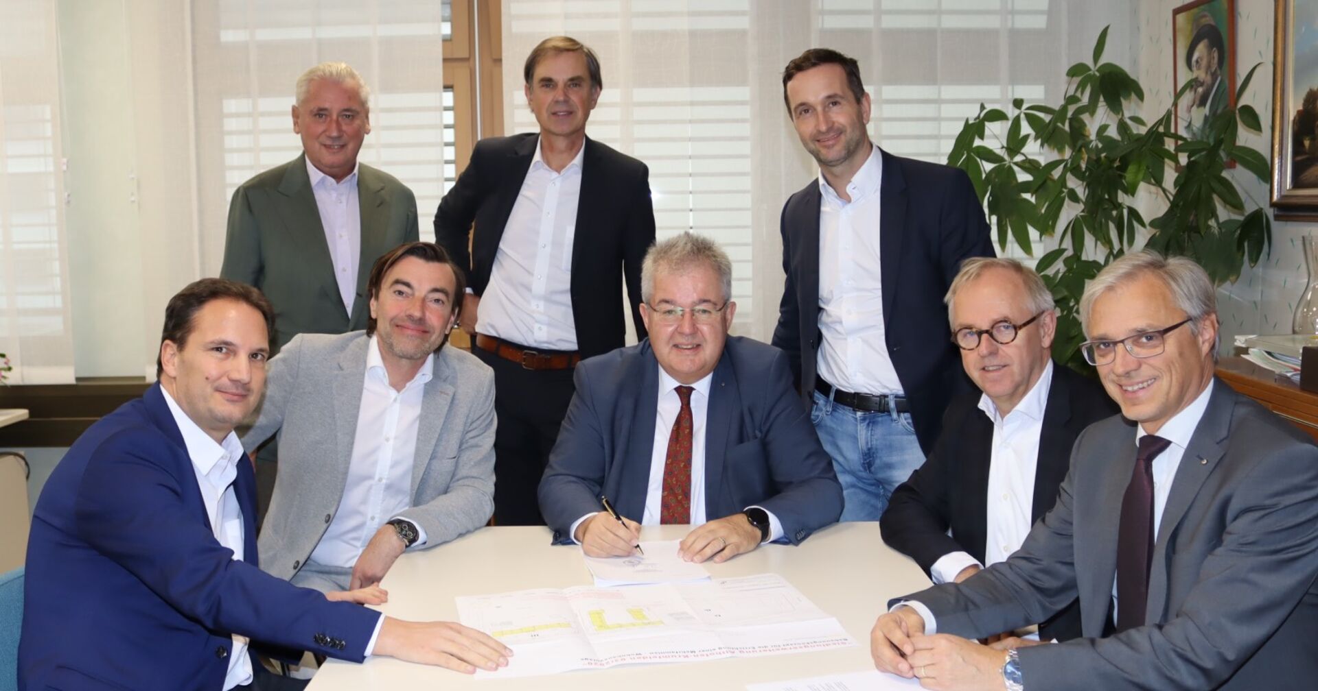8 Männer bei Unterzeichnung des Vertrages
