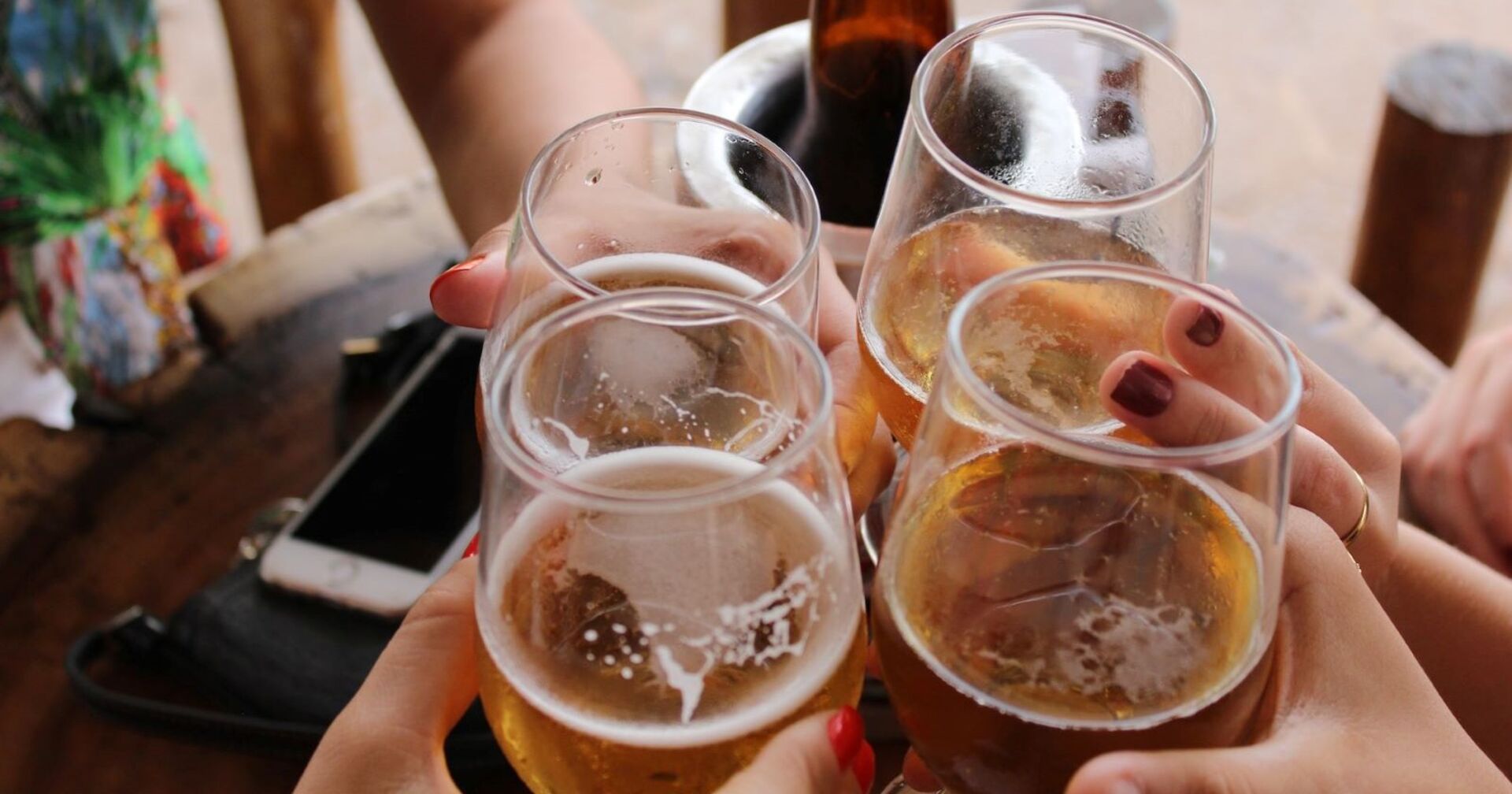 Vier Mencshen stoßen mit Bier an