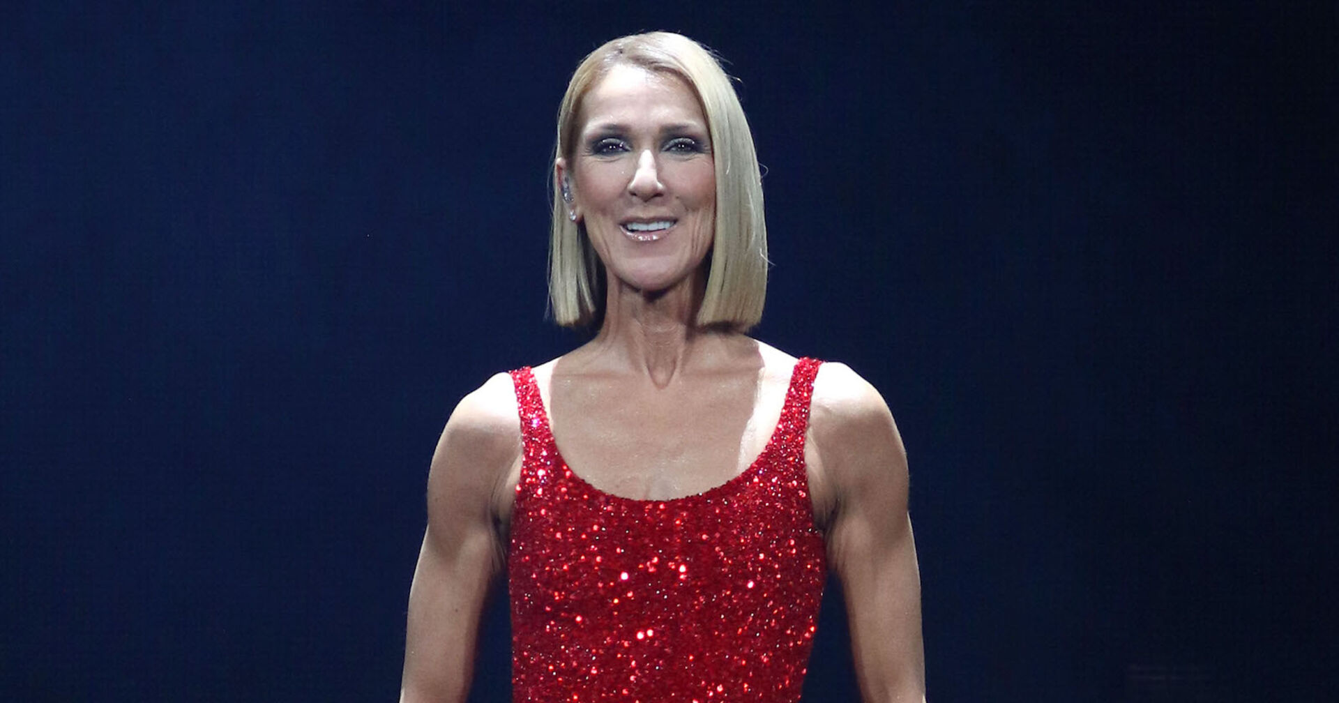 Celin Dion auf der Bühne mit einem roten Kleid das glitzert.
