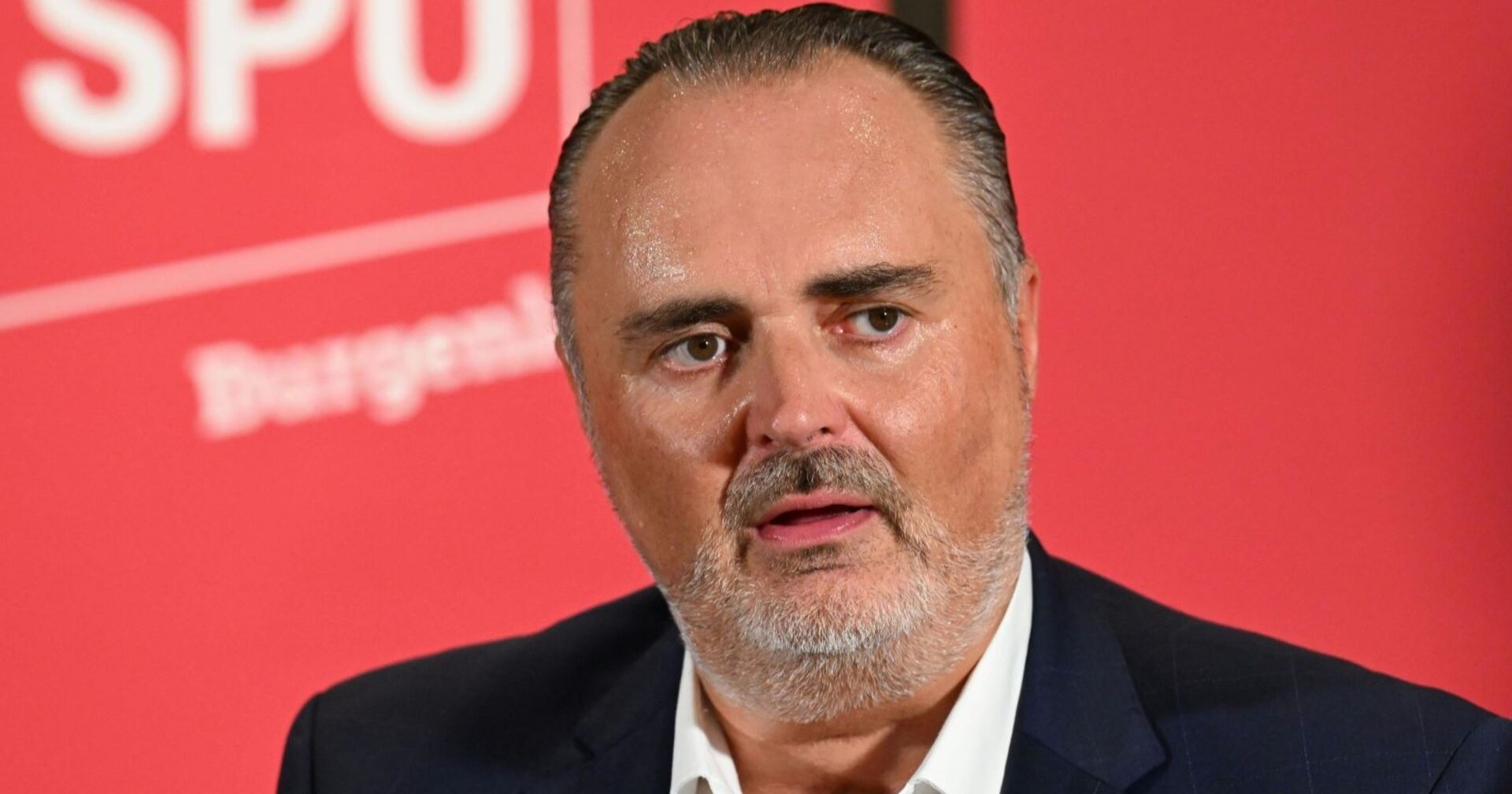 Hans Peter Doskozil im Porträt vor der Pressewand der SPÖ Burgenland