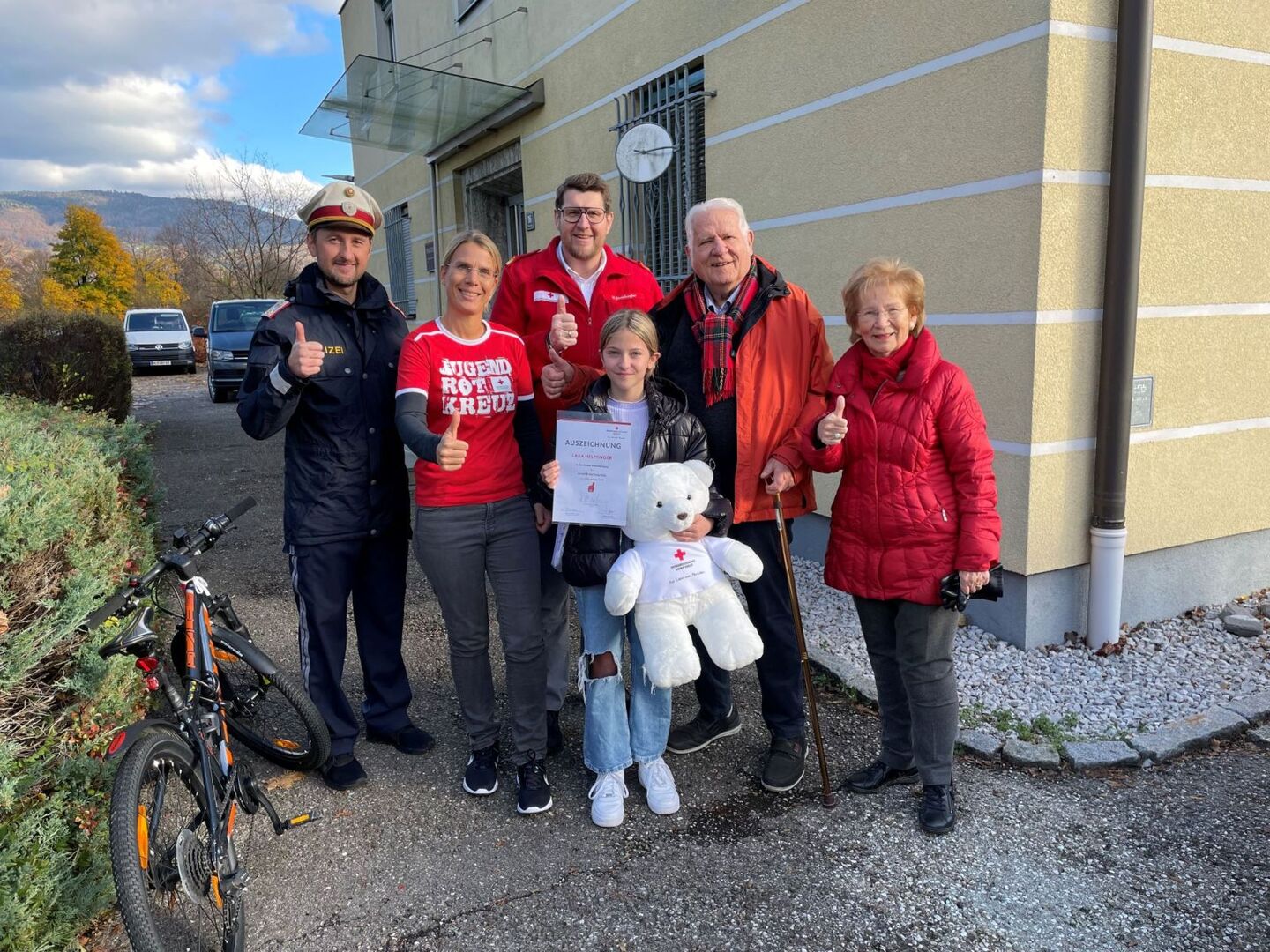 Lara mit dem verunfallten Mann, einem Polizisten und Mitarbeitern des Roten Kreuzes.