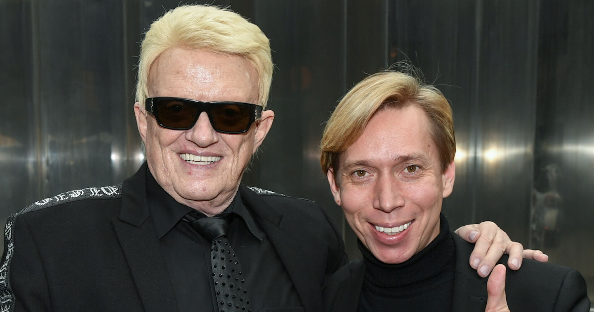 Heino trägt eine schwarze Sonnenbrille und schwarze Kleidung. Er umarmt seinen Manager Helmut Werner der auch schwarz gekleidet ist.