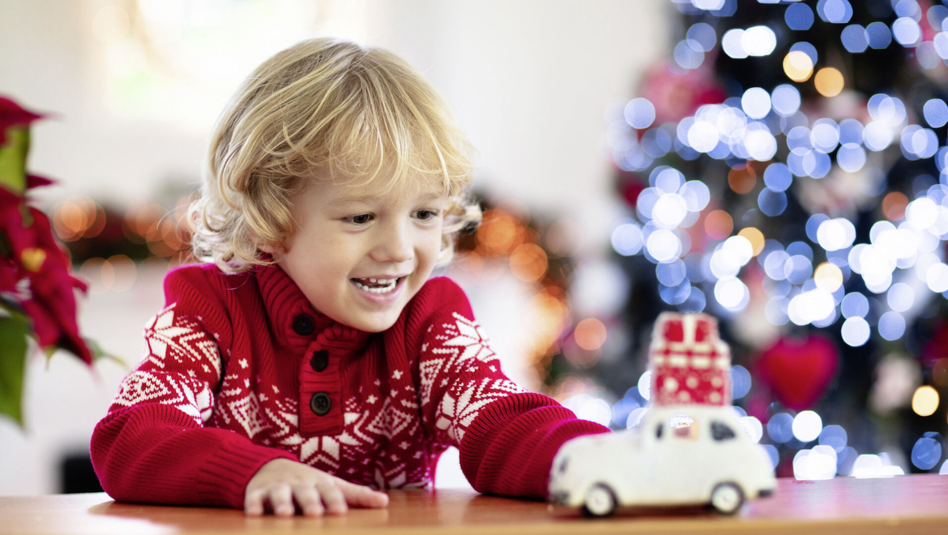 Kind freut sich über Spielauto zu Weihnachten.