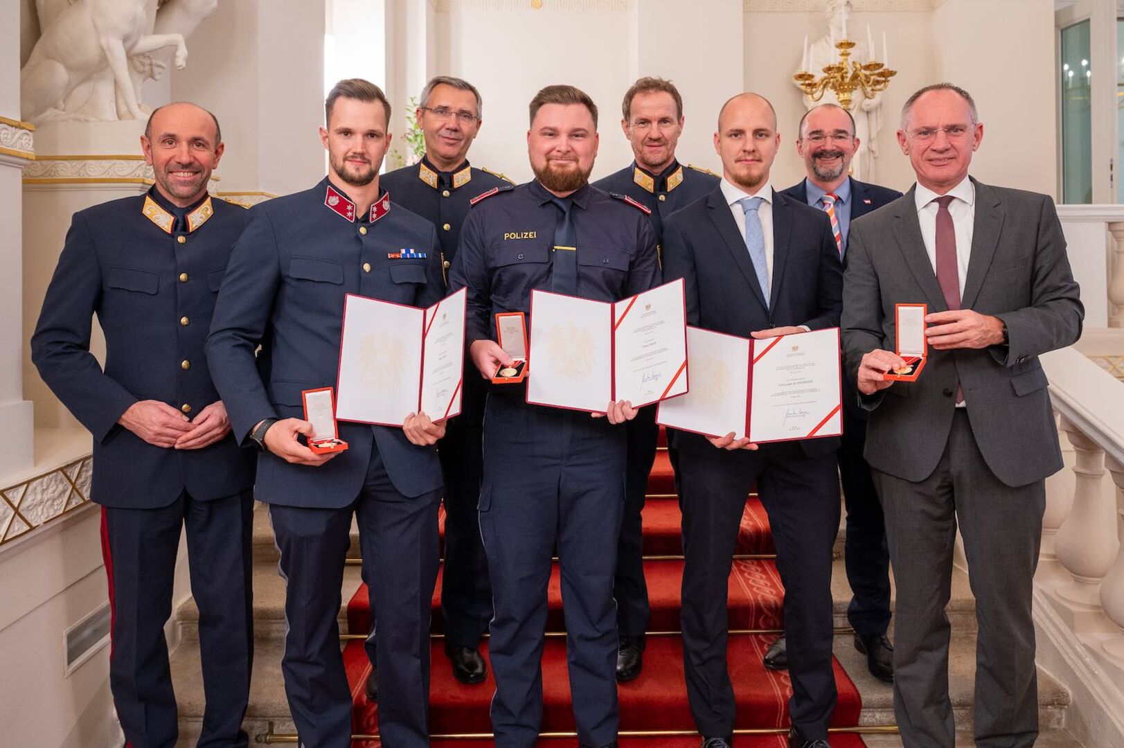 Die Polizisten zeigen stolz ihre Urkunden.