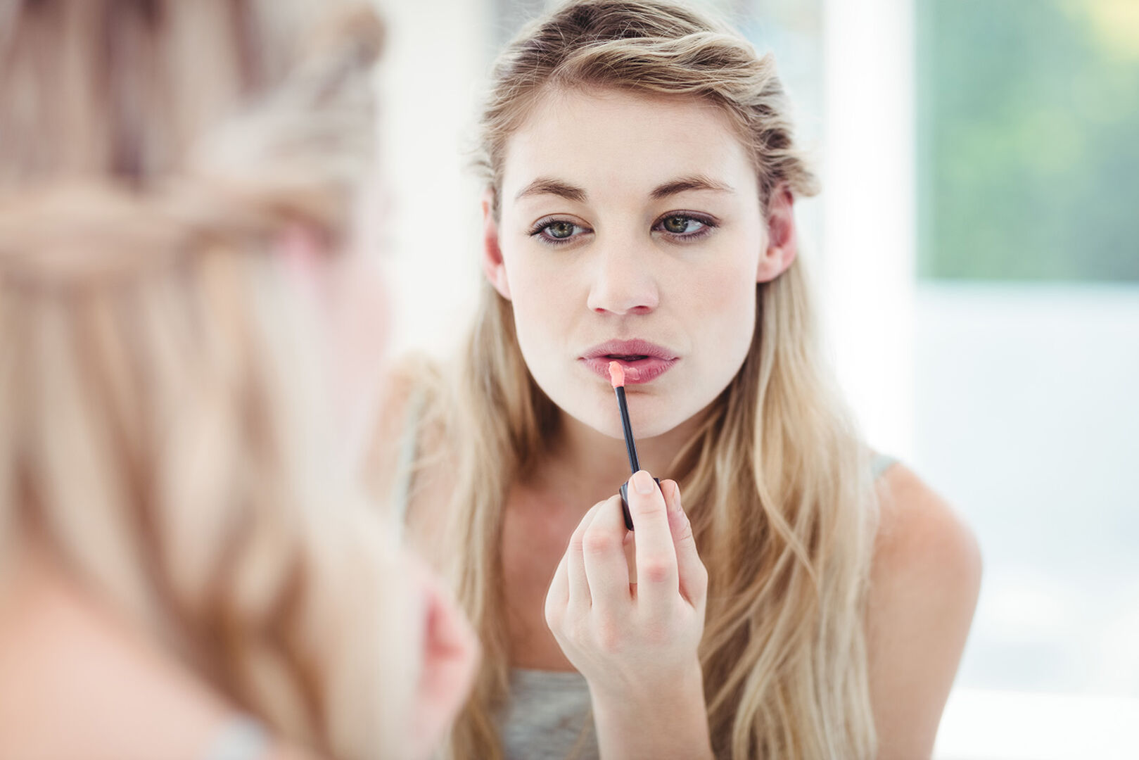 Frau benutzt Lipgloss | Credit: iStock.com/Wavebreakmedia