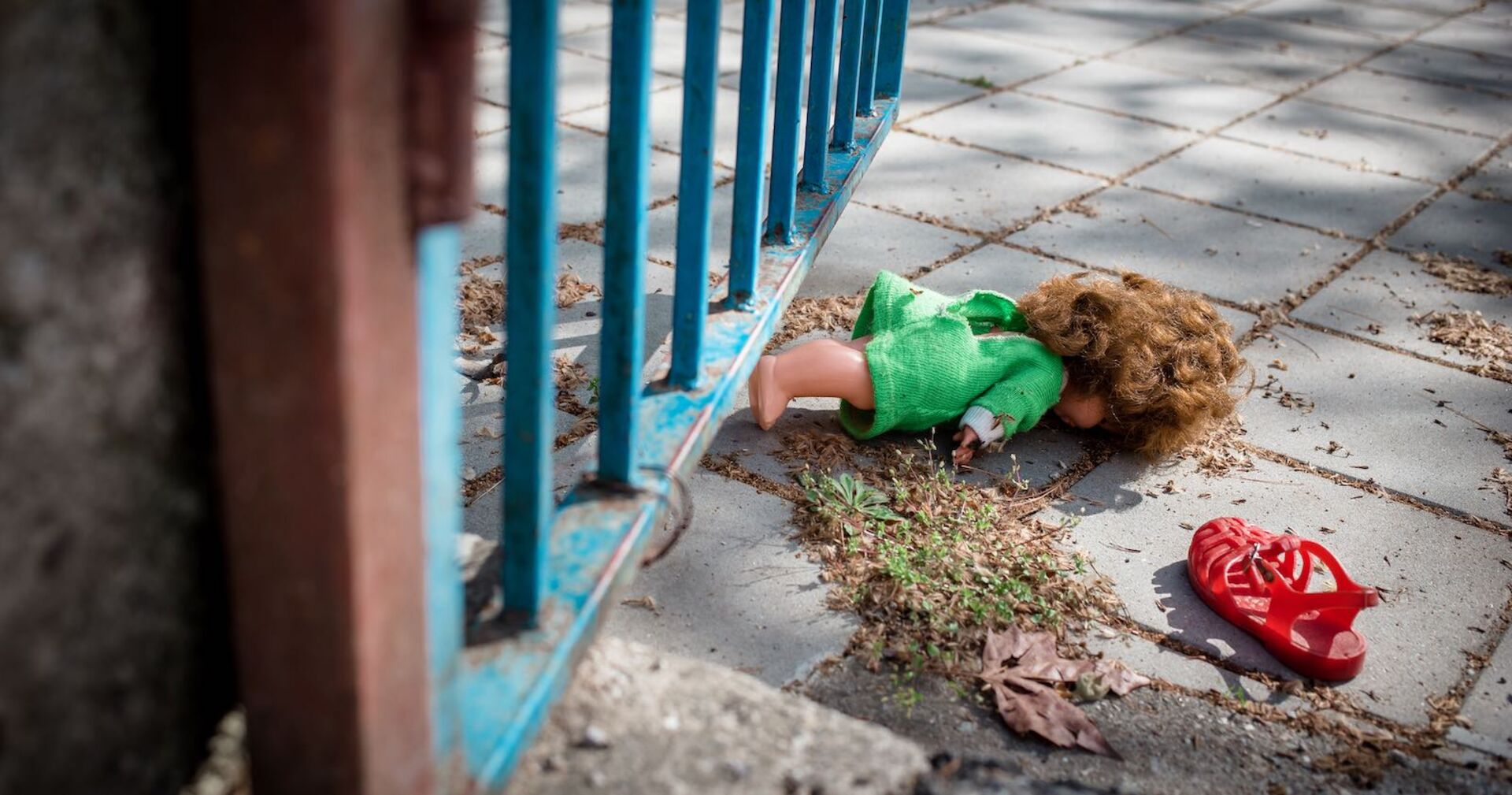 Eine einsame Puppe liegt auf der Straße.