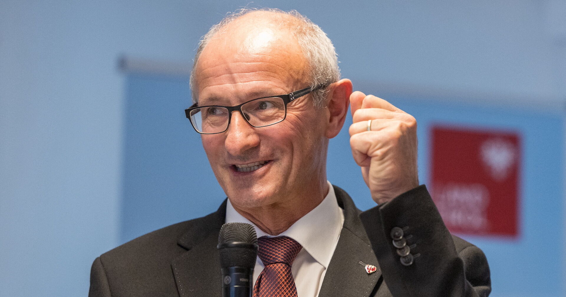 Anton Mattle im Portrait mit einem Mikrofon in der Hand