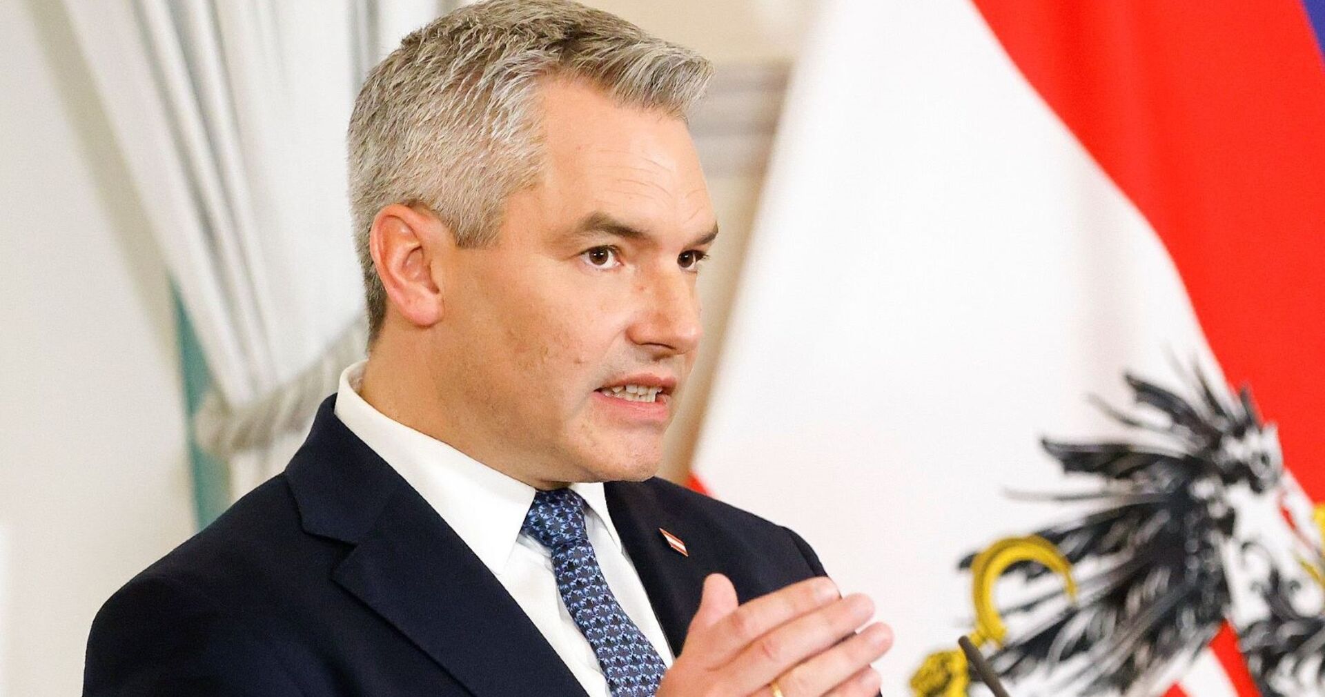 Bundeskanzler Karl Nehammer vor der österreichsichen Flagge.