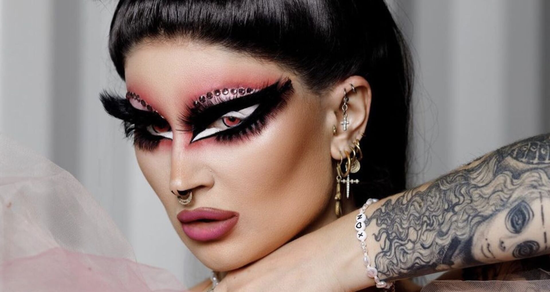 Drag-Künstlerin Pandora Box hat ein starkes Make Up und schwarze Haare.
