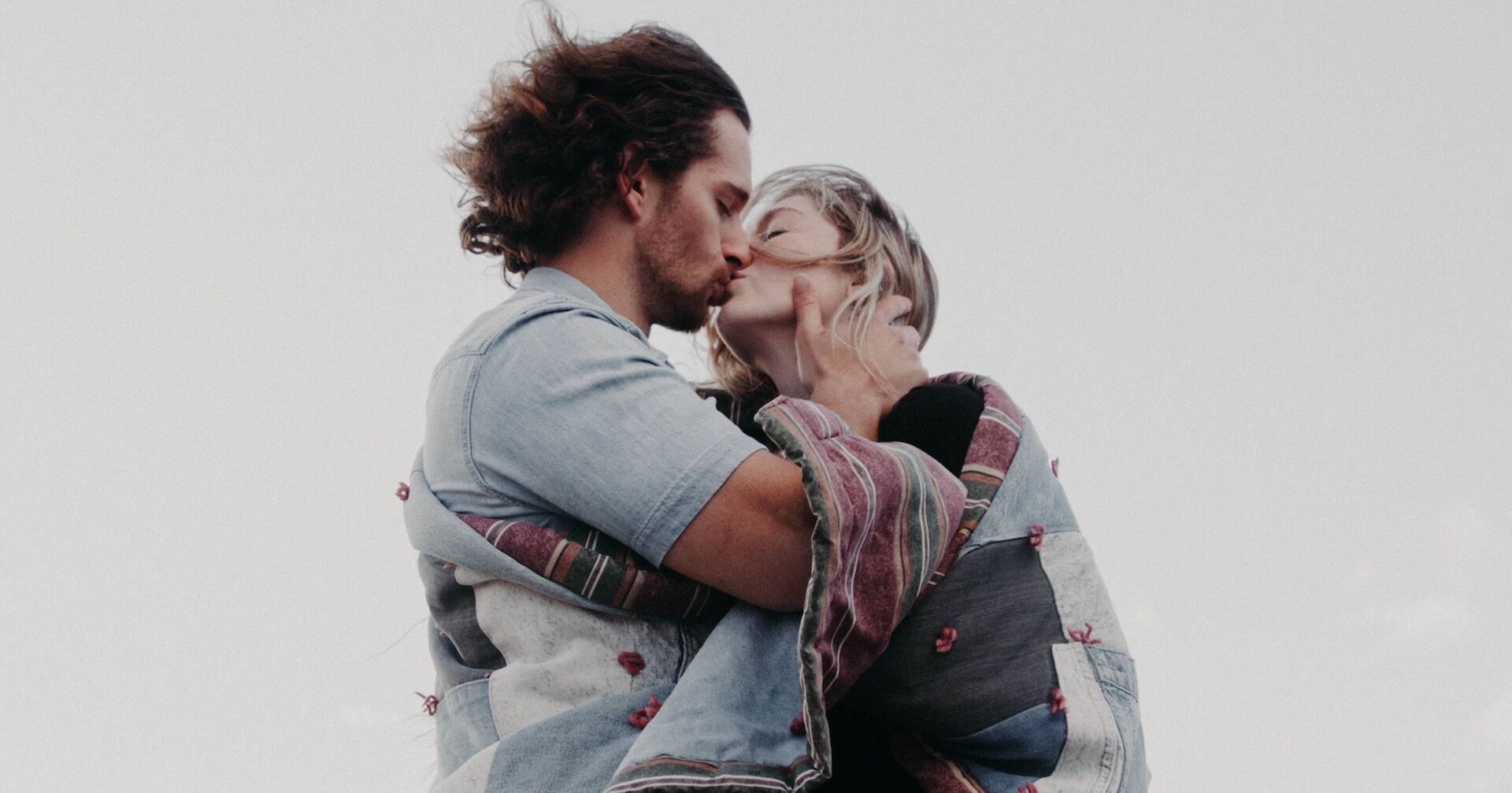 Zwei verliebte Menschen küssen sich im Wind.