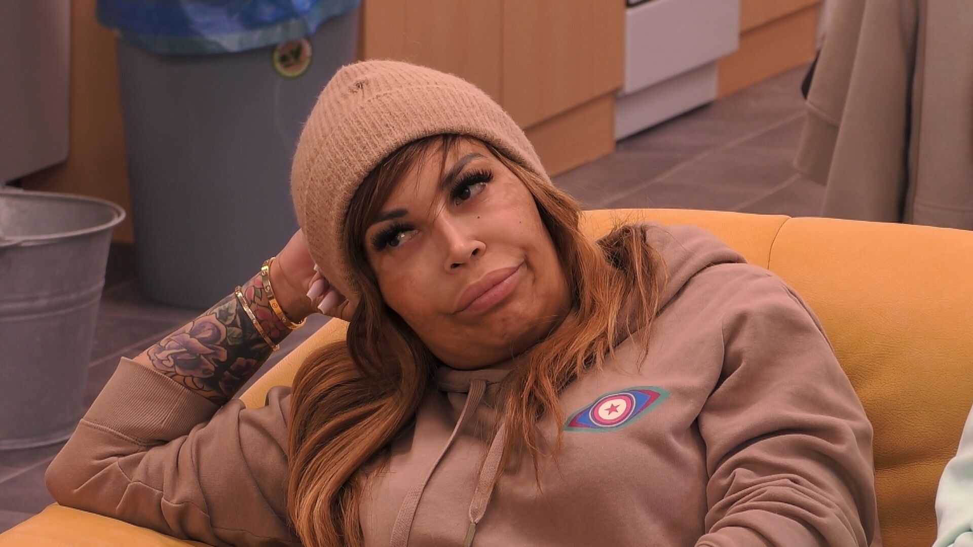 Patricia Blanco trägt einen beigen Hoodie und eine beige Mütze.