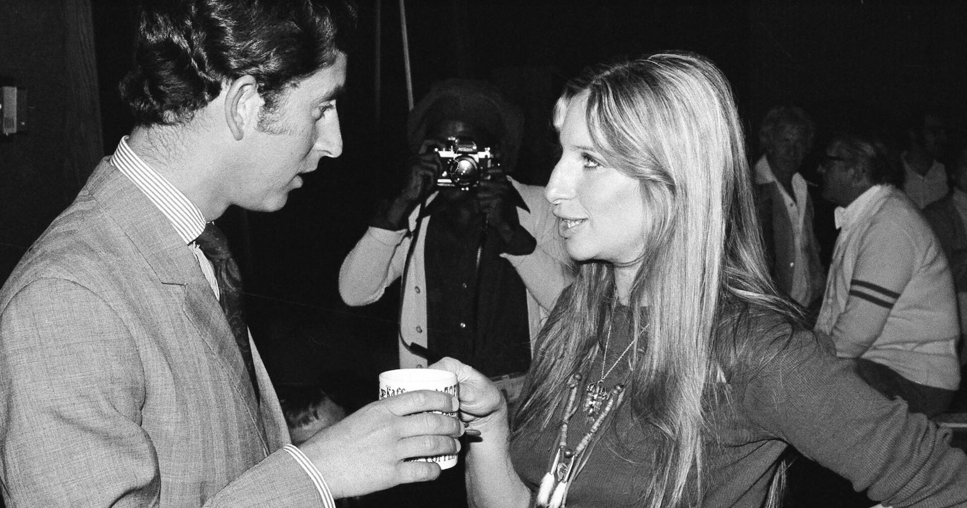 Prince Charles und Barbara Streisand im Jahre 1974 am Set von &quot;FunnyGirl.&quot; Sie unterhalten sich und trinken eine Tasse Tee.