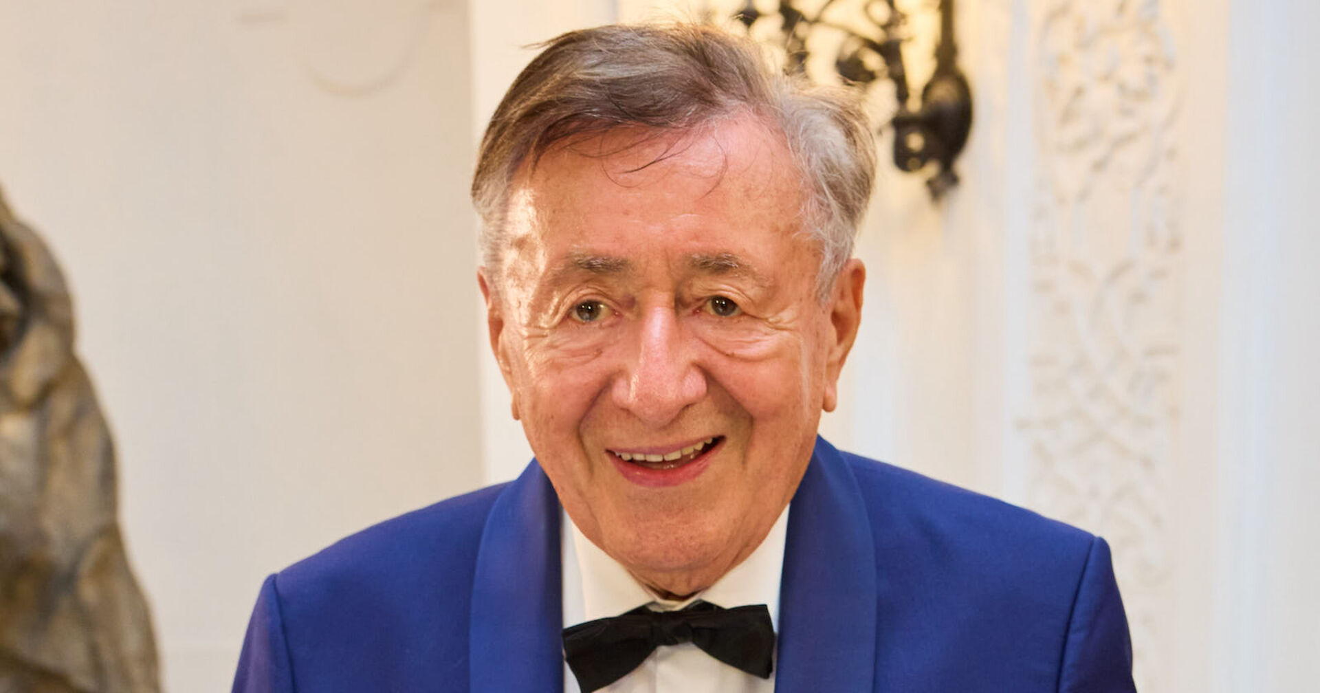 Baumeister Richard Lugner trägt einen dunkelblauen Anzug und eine schwarze Fliege.